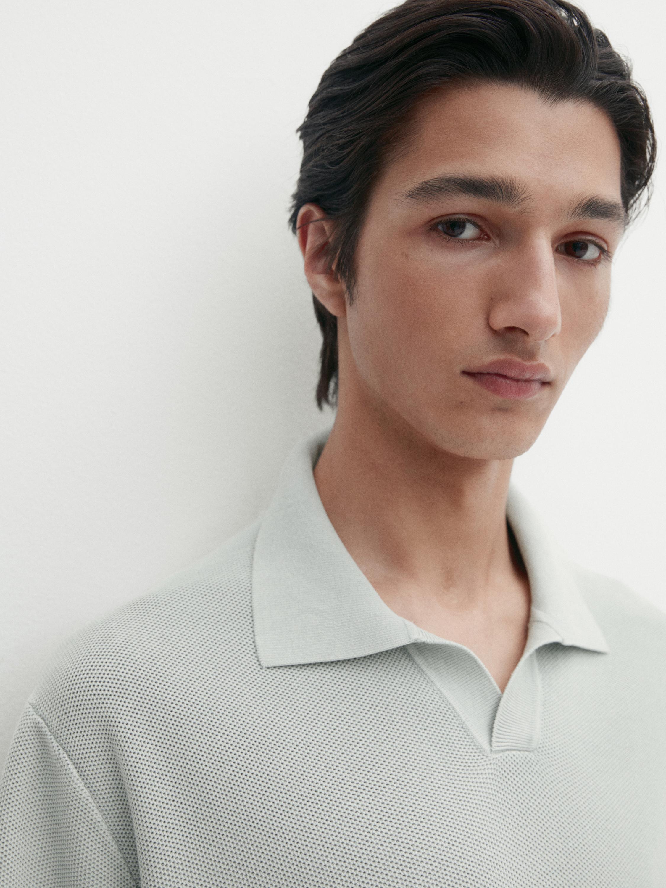 Plan moyen d'un polo gris clair à col classique.