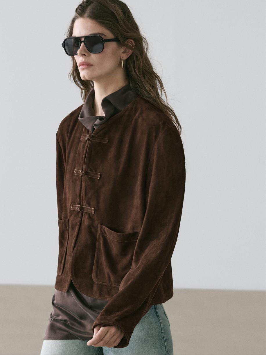 Medium shot of a brown jacket with a tie closure and front pockets.
