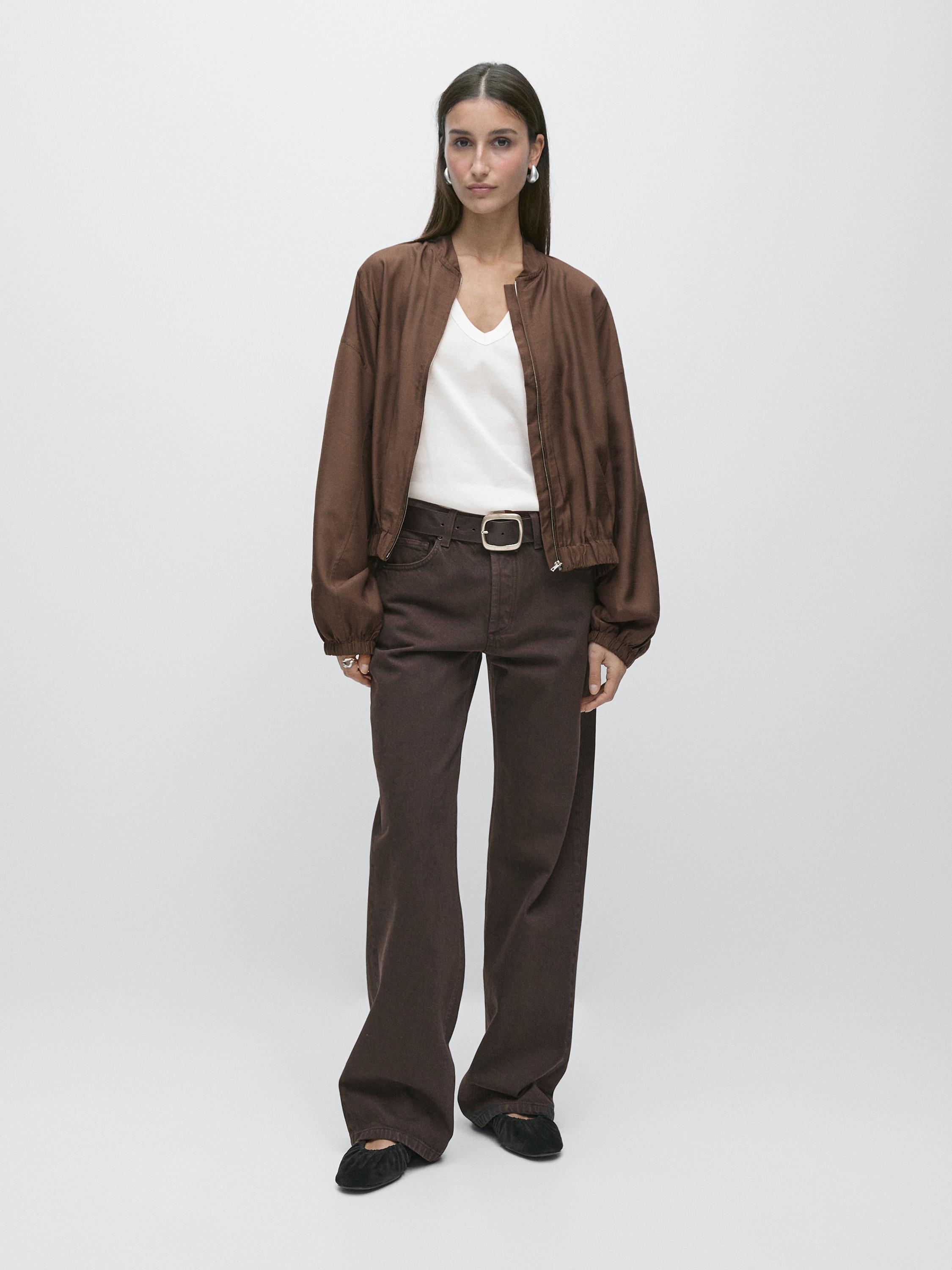 Flowy brown bomber jacket set, white V-neck t-shirt, brown wide-leg pants, and black shoes.