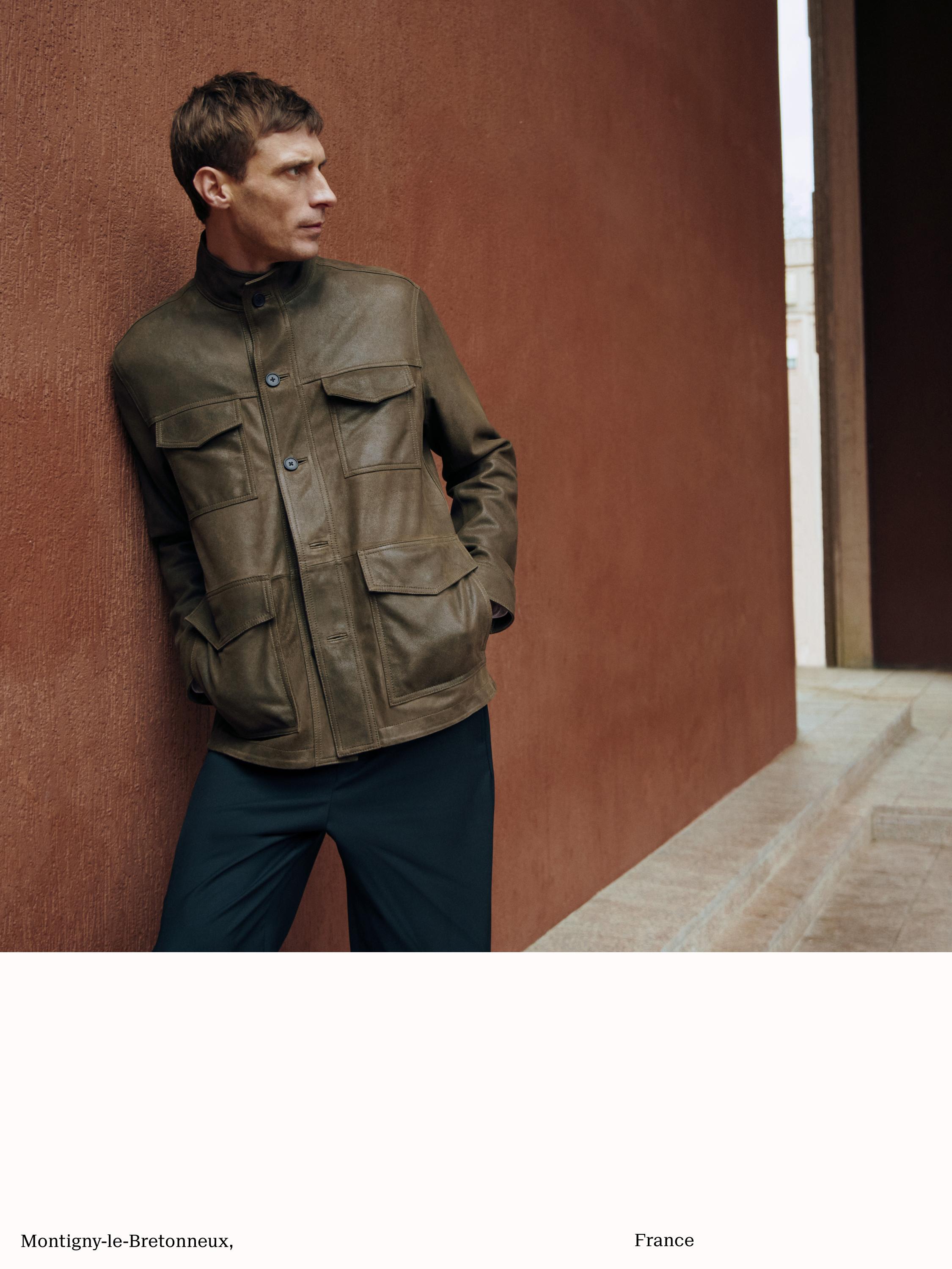 Комплект: бомбер цвета хаки с передними карманами с клапанами и темные брюки.