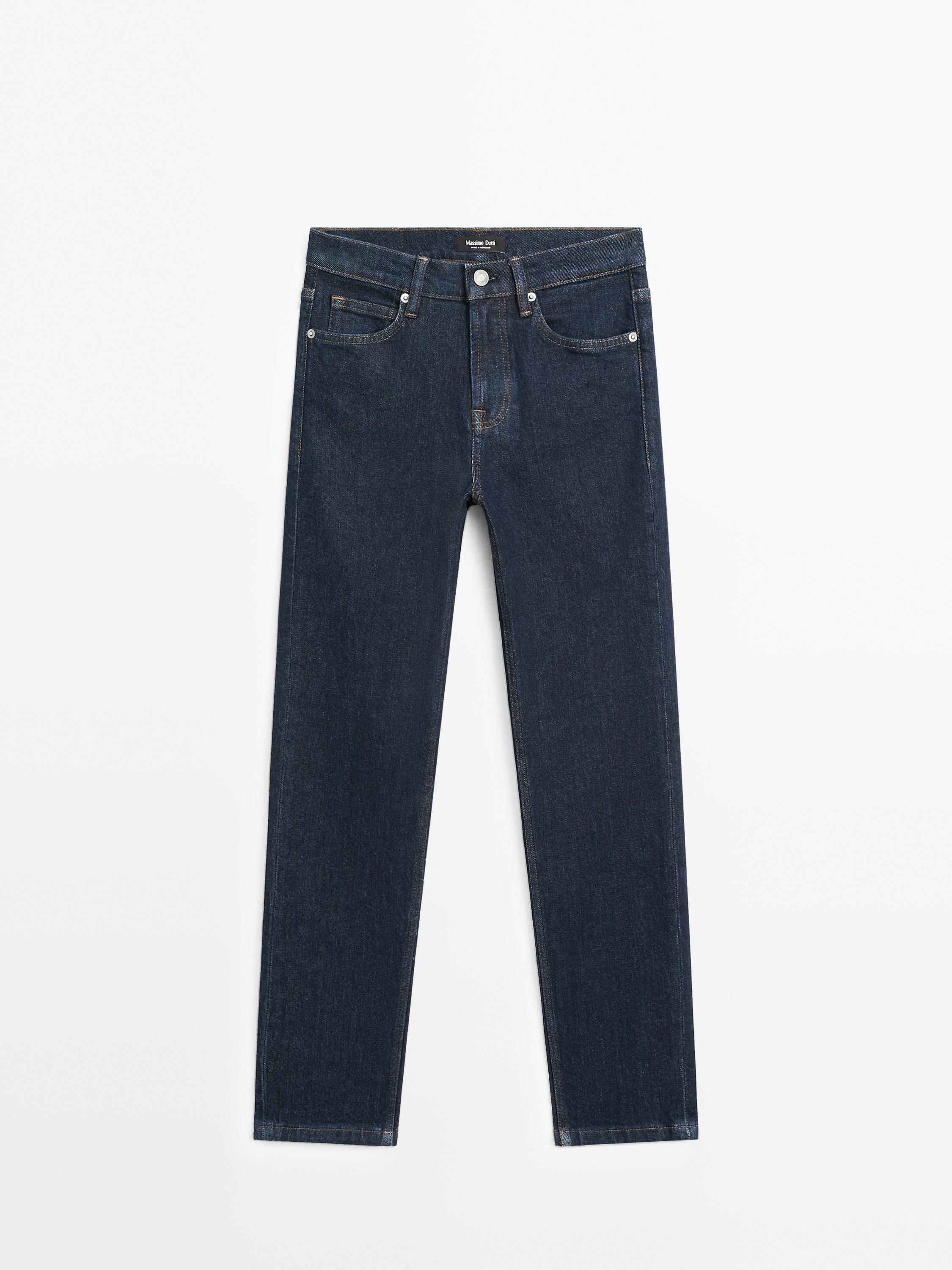 Front view of slim fit black jeans, mid rise, with front and back pockets, button and zipper closure.