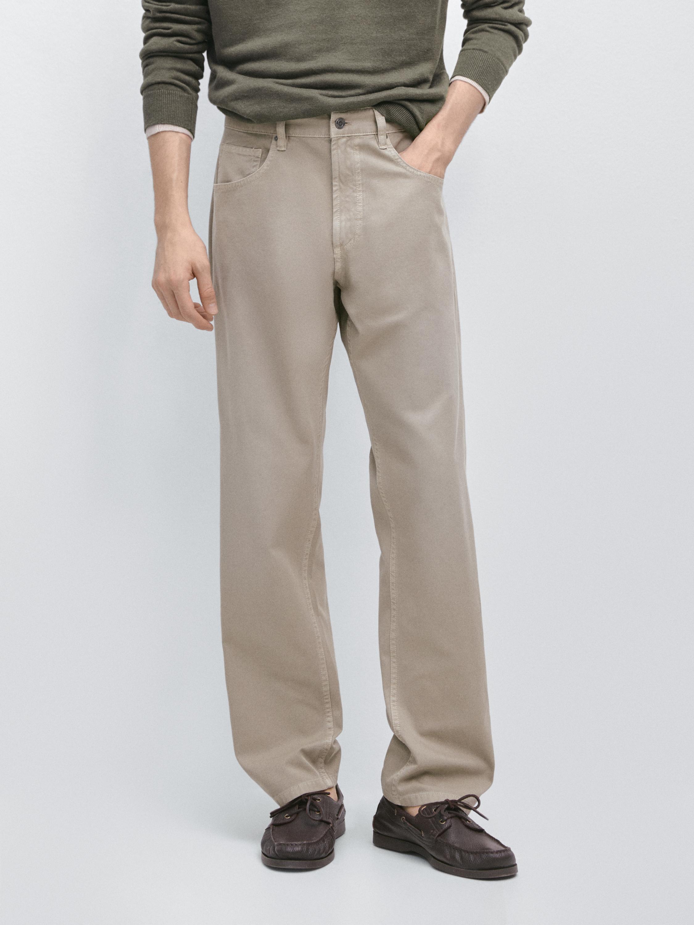 Conjunt de texans verd clar relaxed fit amb butxaques laterals i botó frontal, combinats amb sabates marrons.