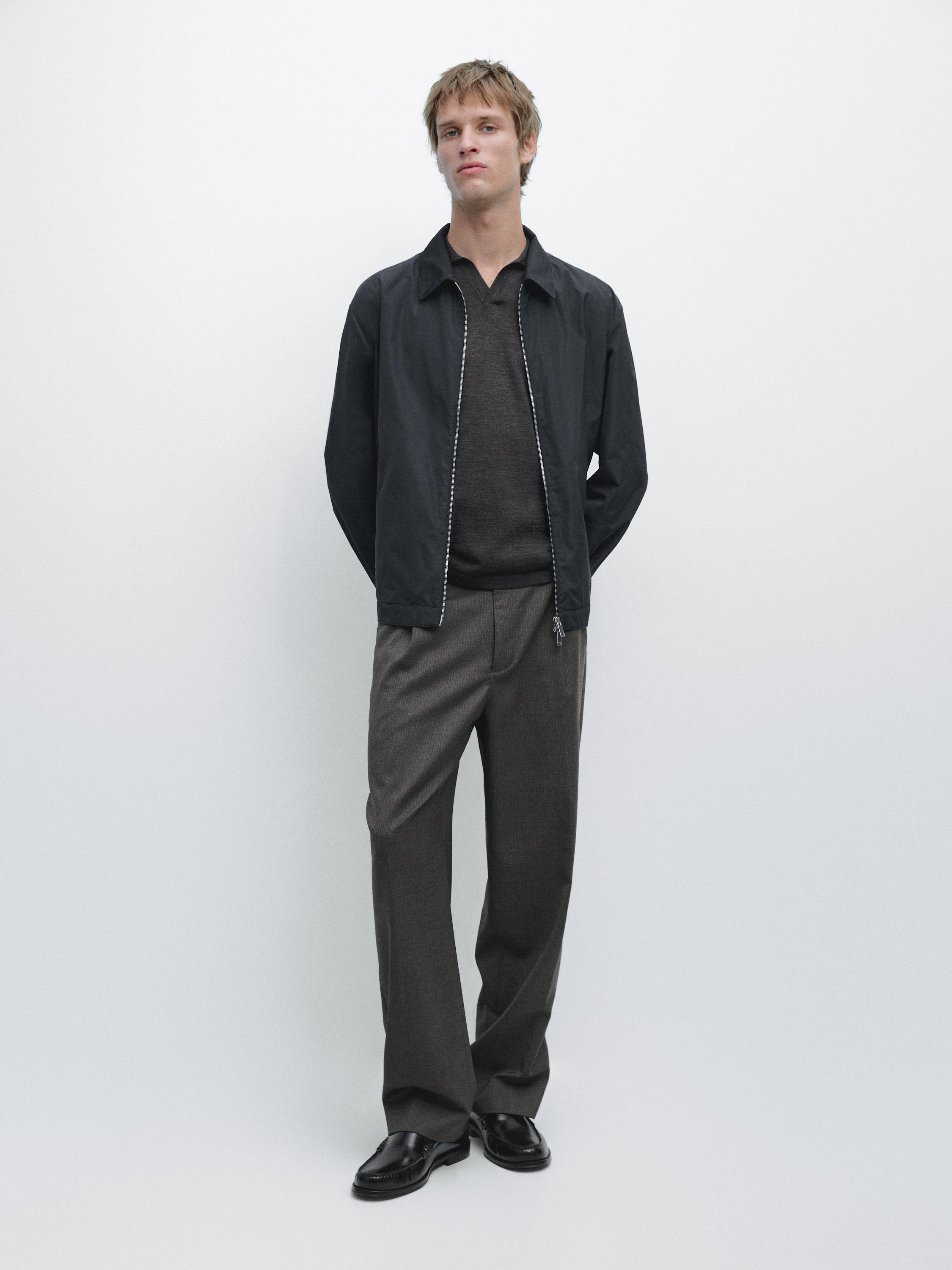 Navy blue zip-up jacket set, straight gray pants, and black shoes.