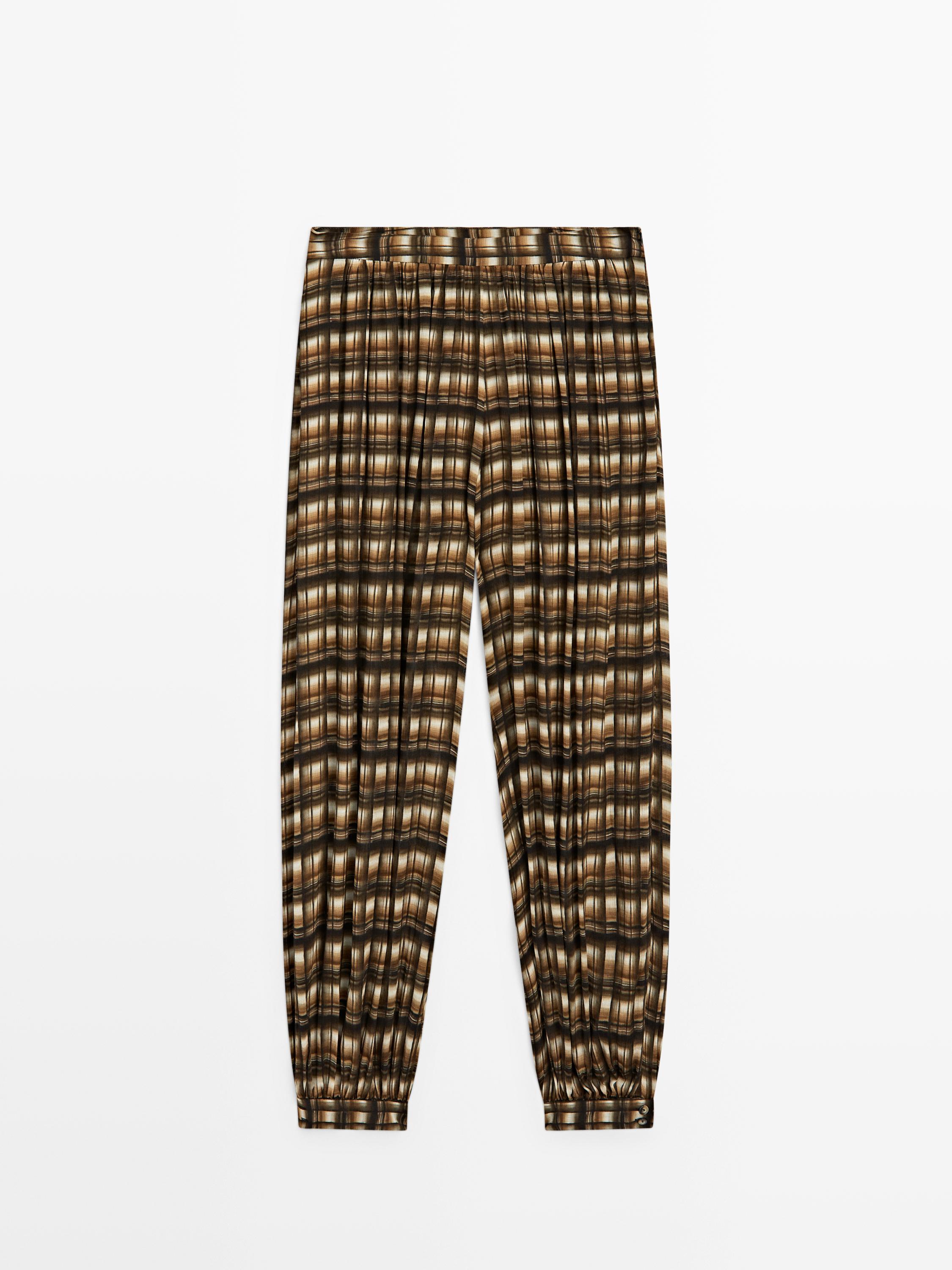 Prednji pogled na culotte hlače s uzorkom u boji senfa s elastičnim pojasom i uskim manžetama.