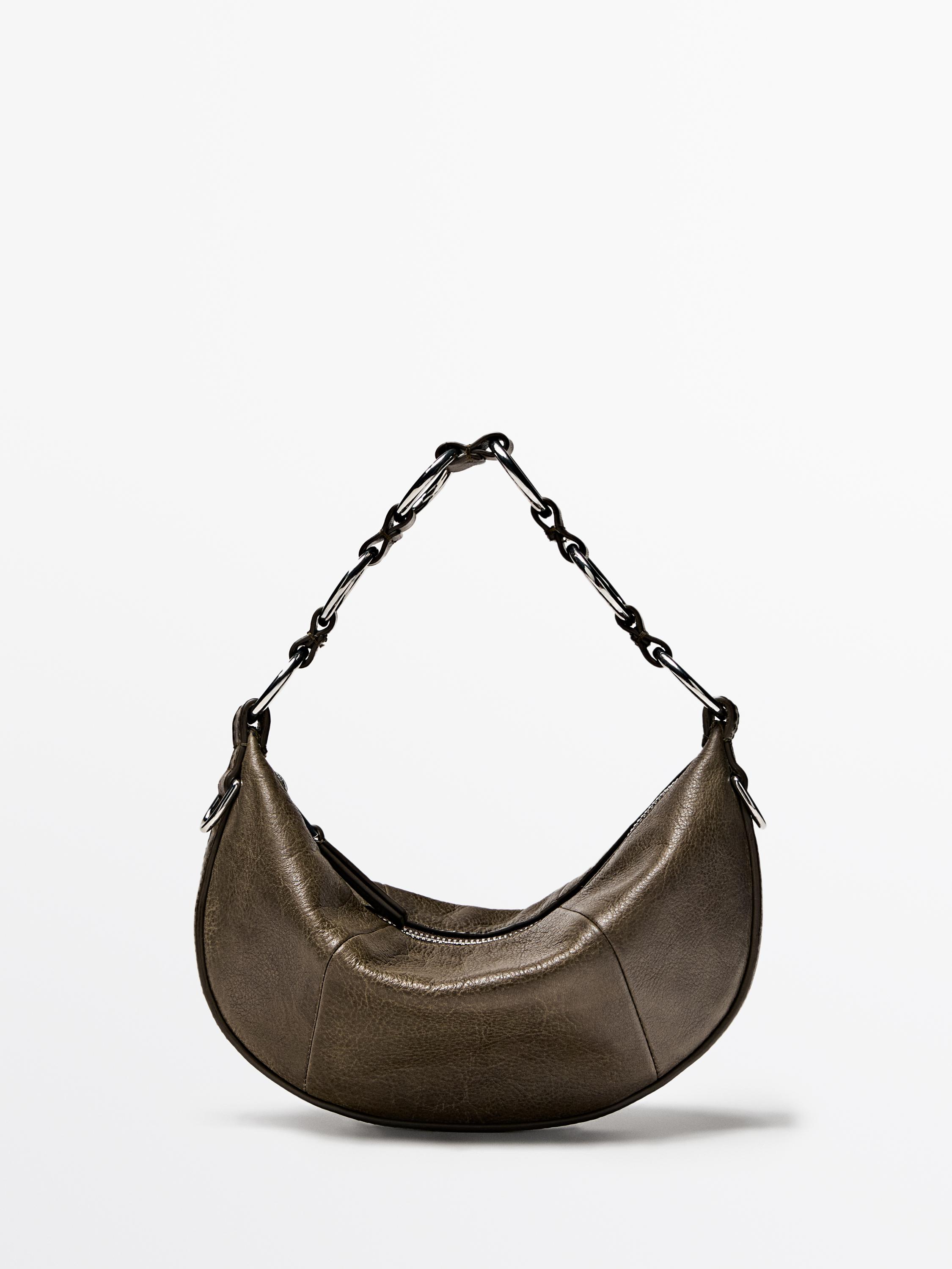 Front view of a mini khaki-colored handbag with a black chain strap and top zipper closure.