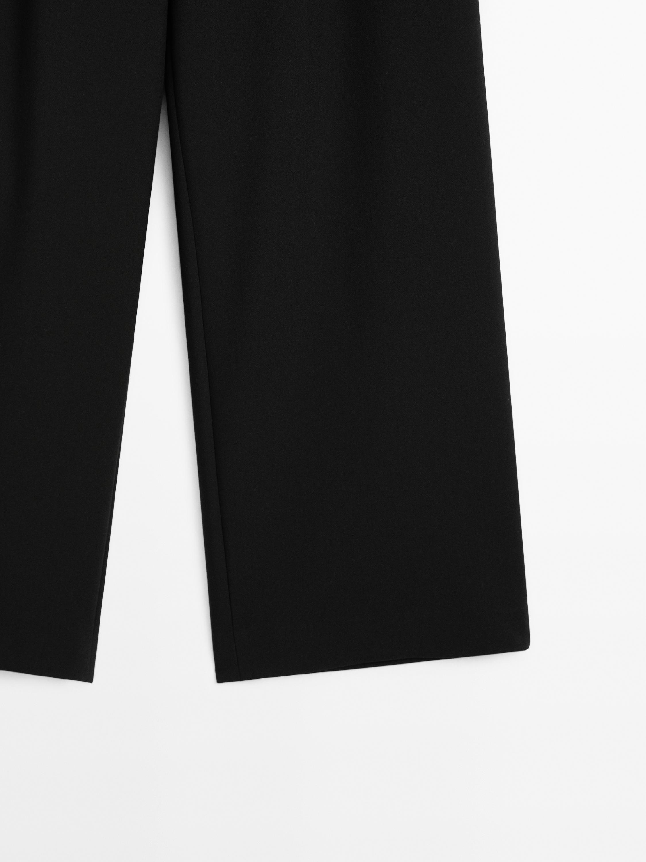 Pantalón tiro medio fluído detalle fibelas