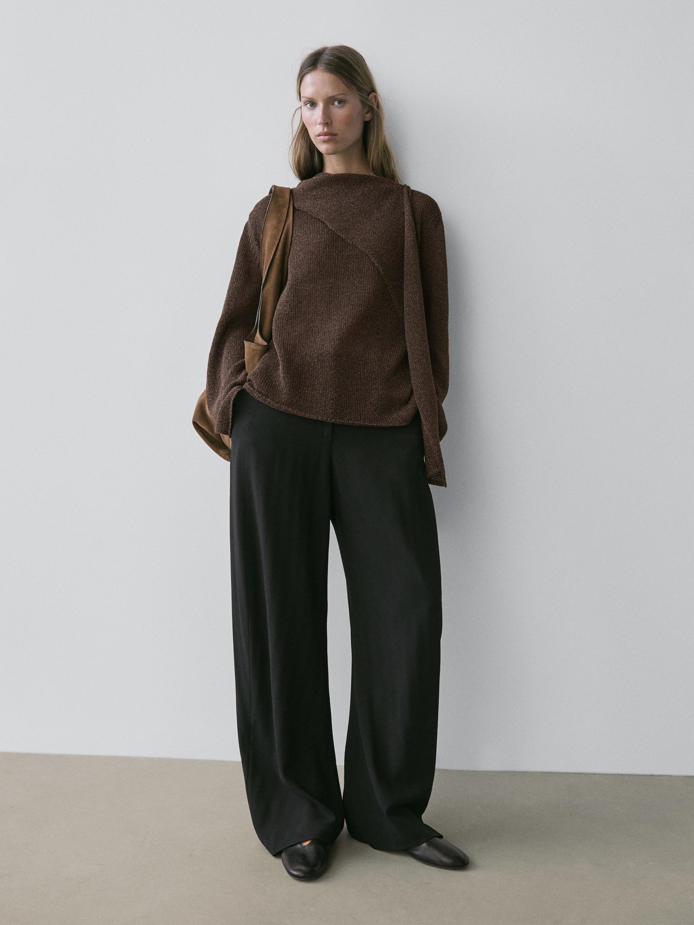 Strickpullover-Set in Schokolade mit geometrischem Design und weiten schwarzen Hosen.