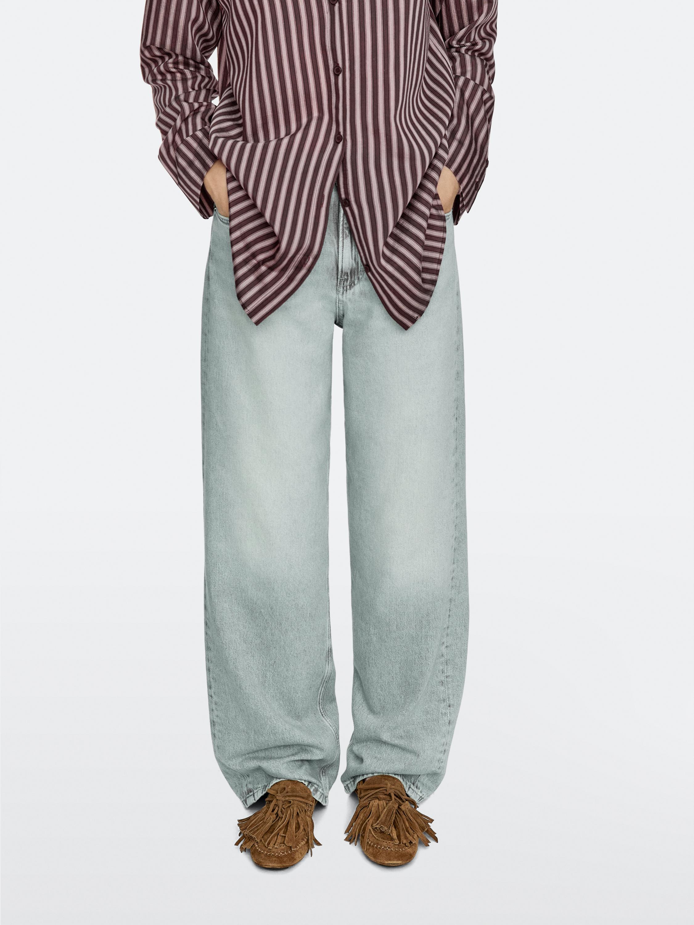 Brown striped shirt set, light blue wide-leg jeans, and fringed and tasselled leather loafers.