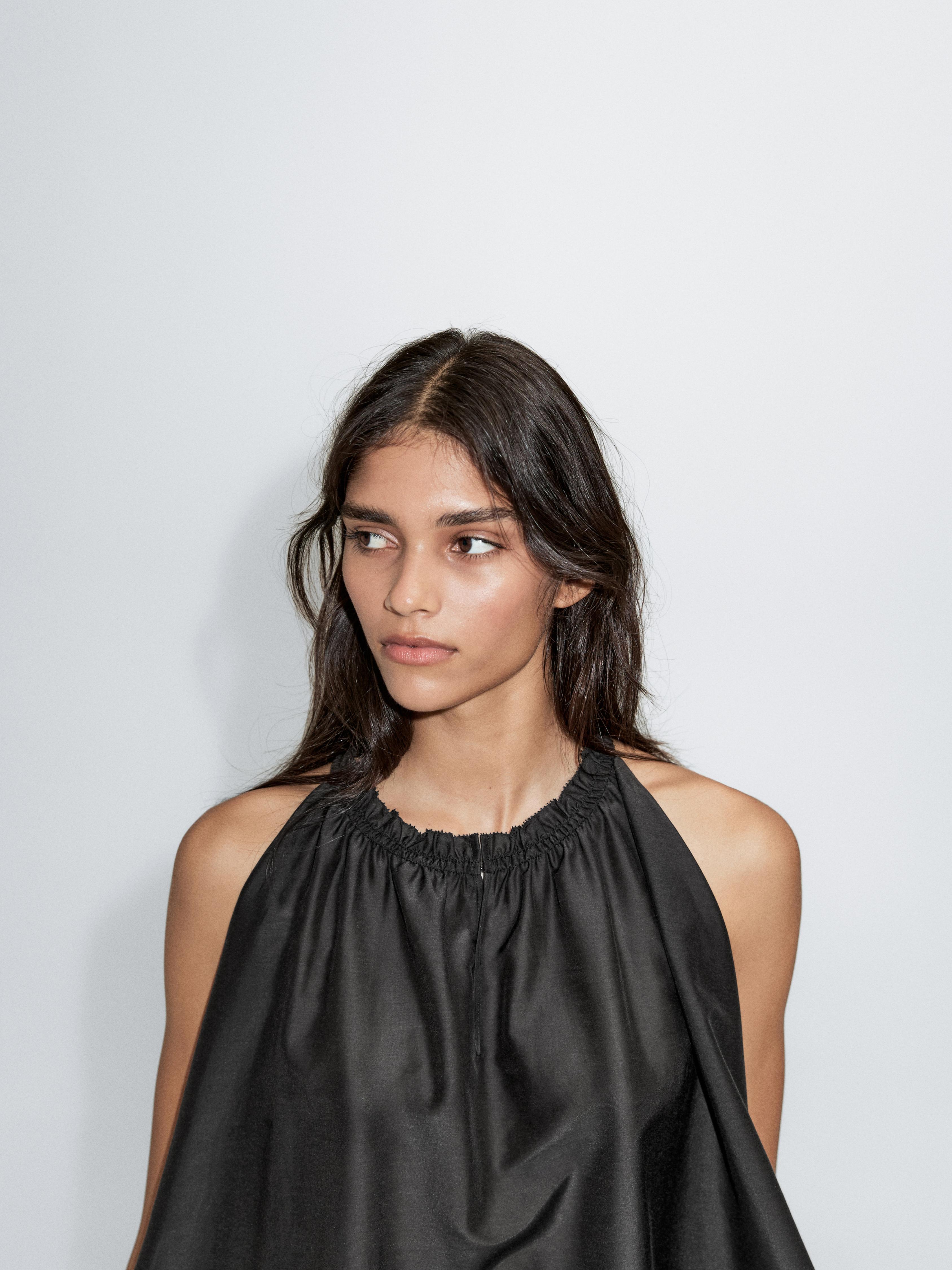 Medium shot of a black top with a ruched neckline.