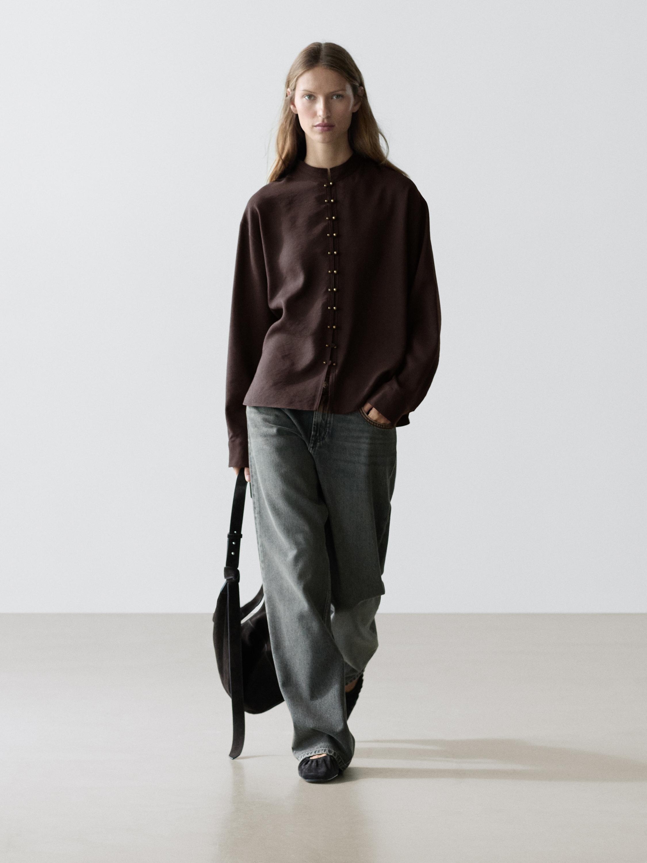 Terracotta button-down shirt set with gray wide-leg jeans.