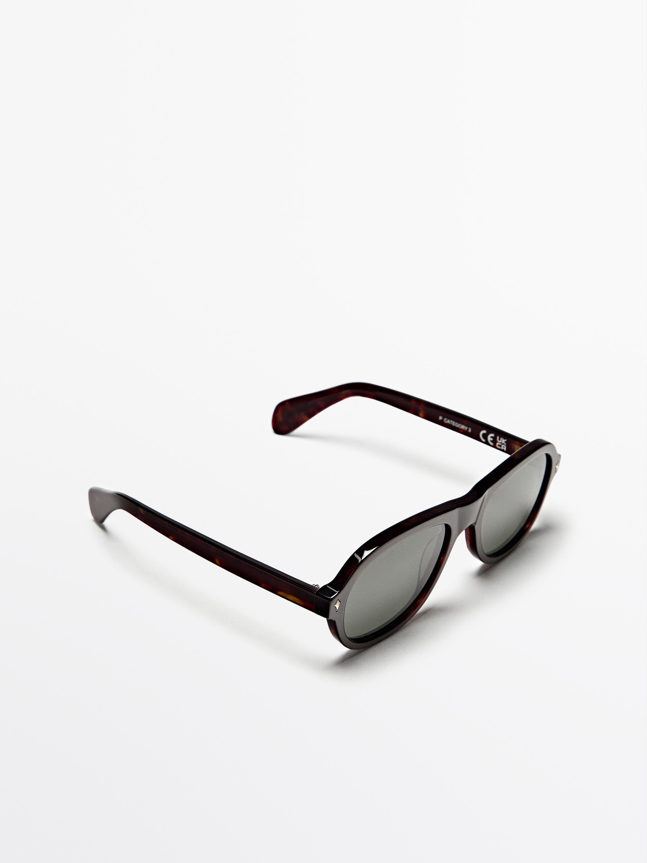 Ovel çerçeveli ve koyu camlı kahverengi güneş gözlüğü. İç sapta "CE" metin detayı.