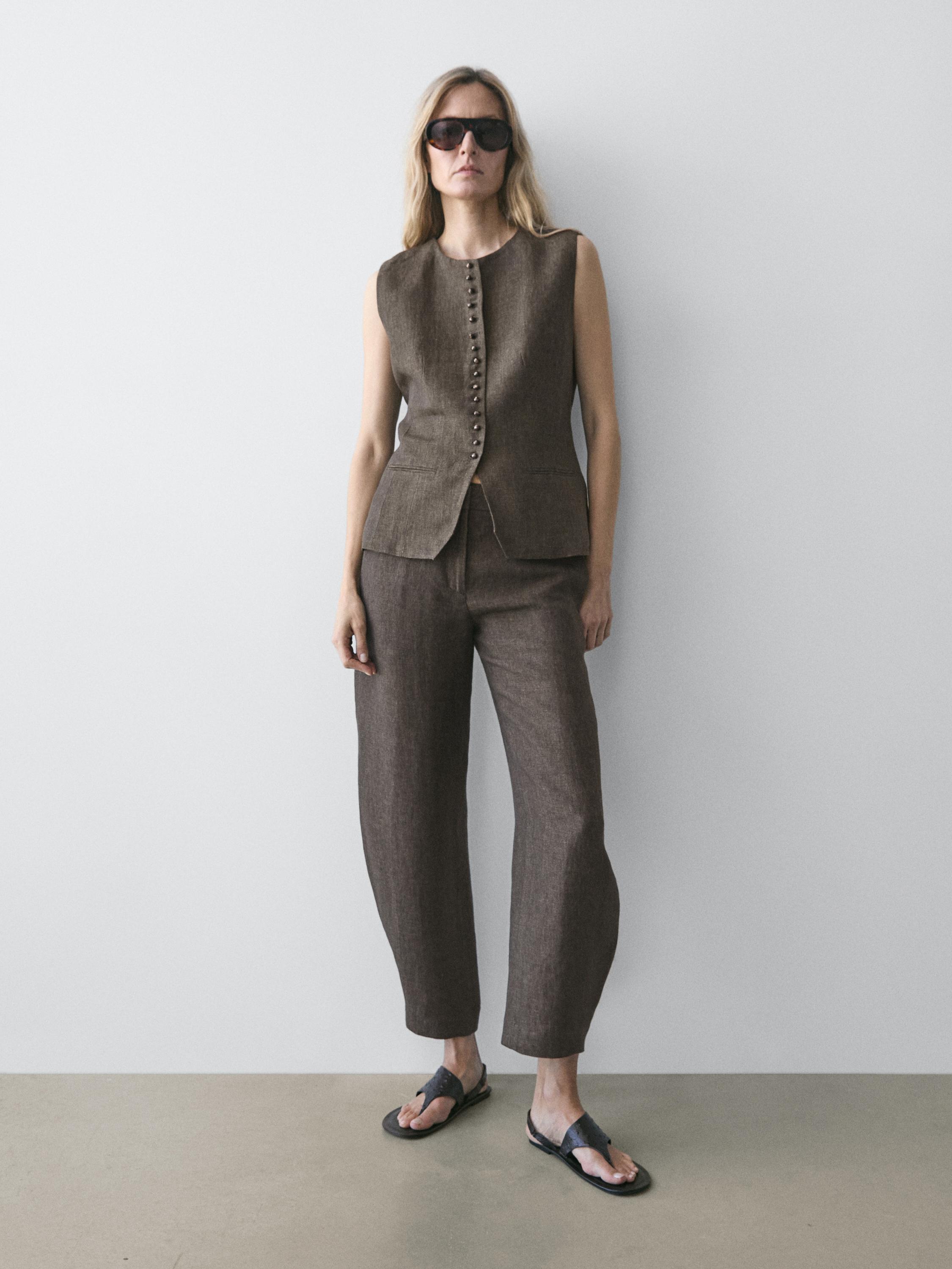 Conjunto de chaleco marrón sin mangas con botonadura frontal y pantalones marrones rectos.