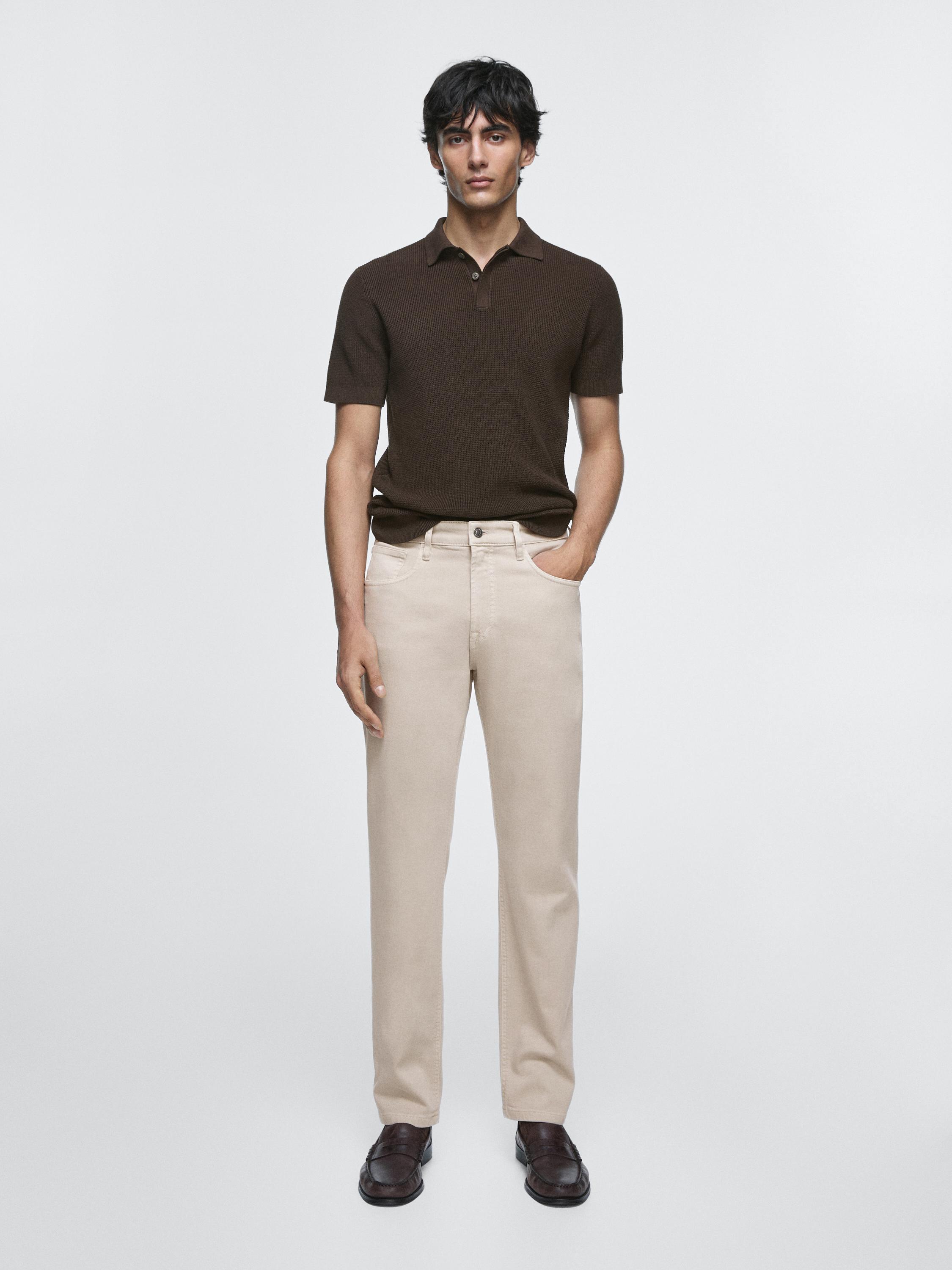 Conjunto de polo marrón de manga corta y jeans piedra de corte recto con bolsillos laterales.