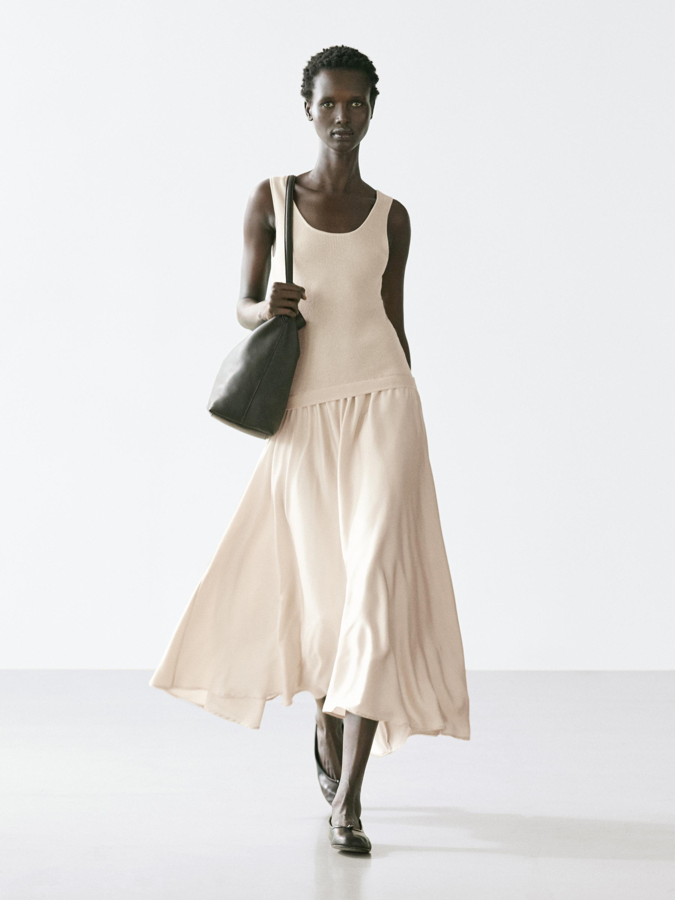 Conjunto de vestido beige de tirantes con falda amplia y larga.