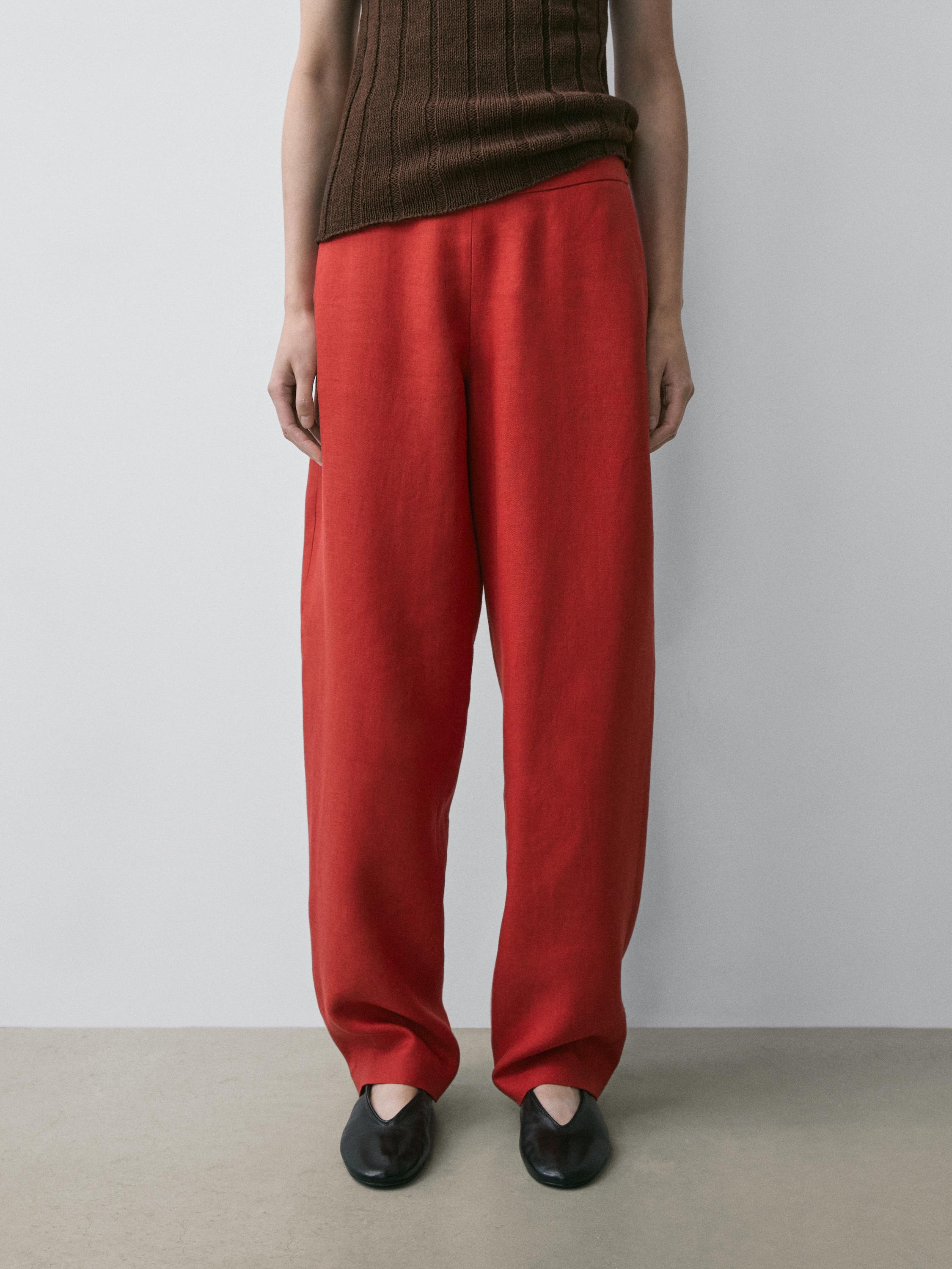 Ensemble pantalon rouge volumineux avec top côtelé marron.