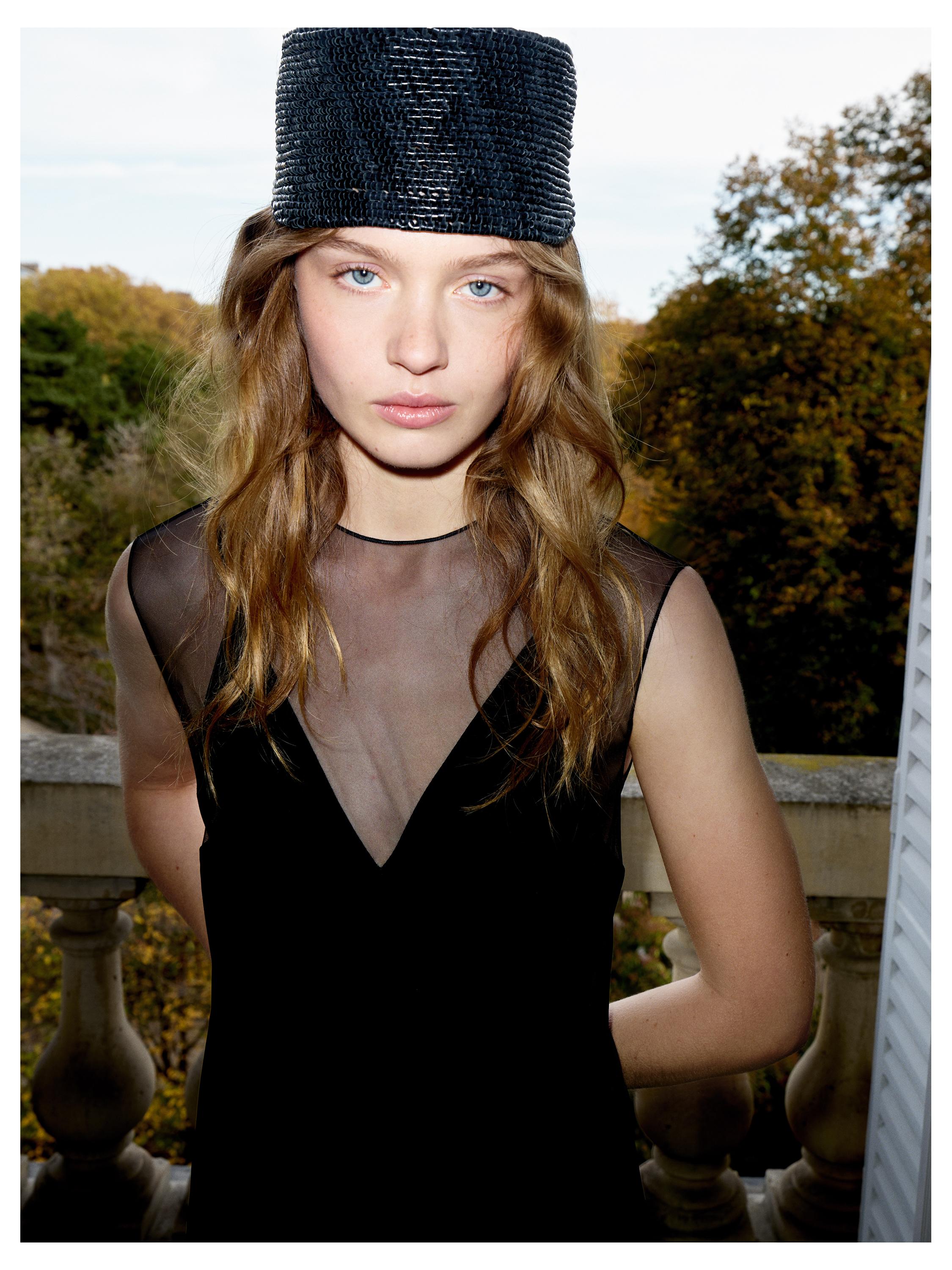 Средний план длинного черного платья с прозрачной вставкой на вырезе.