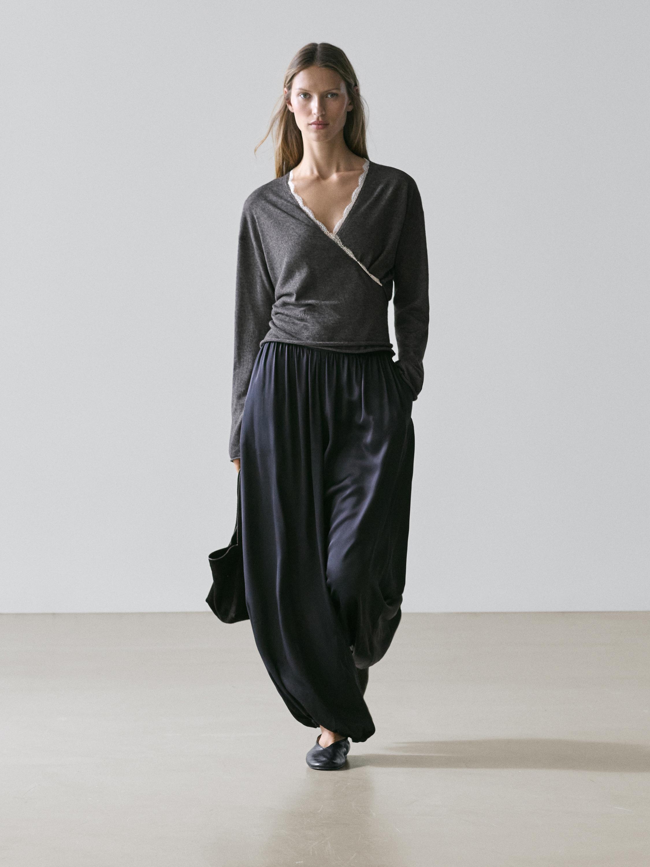 Conjunto de cárdigan gris antracita cruzado con detalle de encaje y pantalones anchos negros.