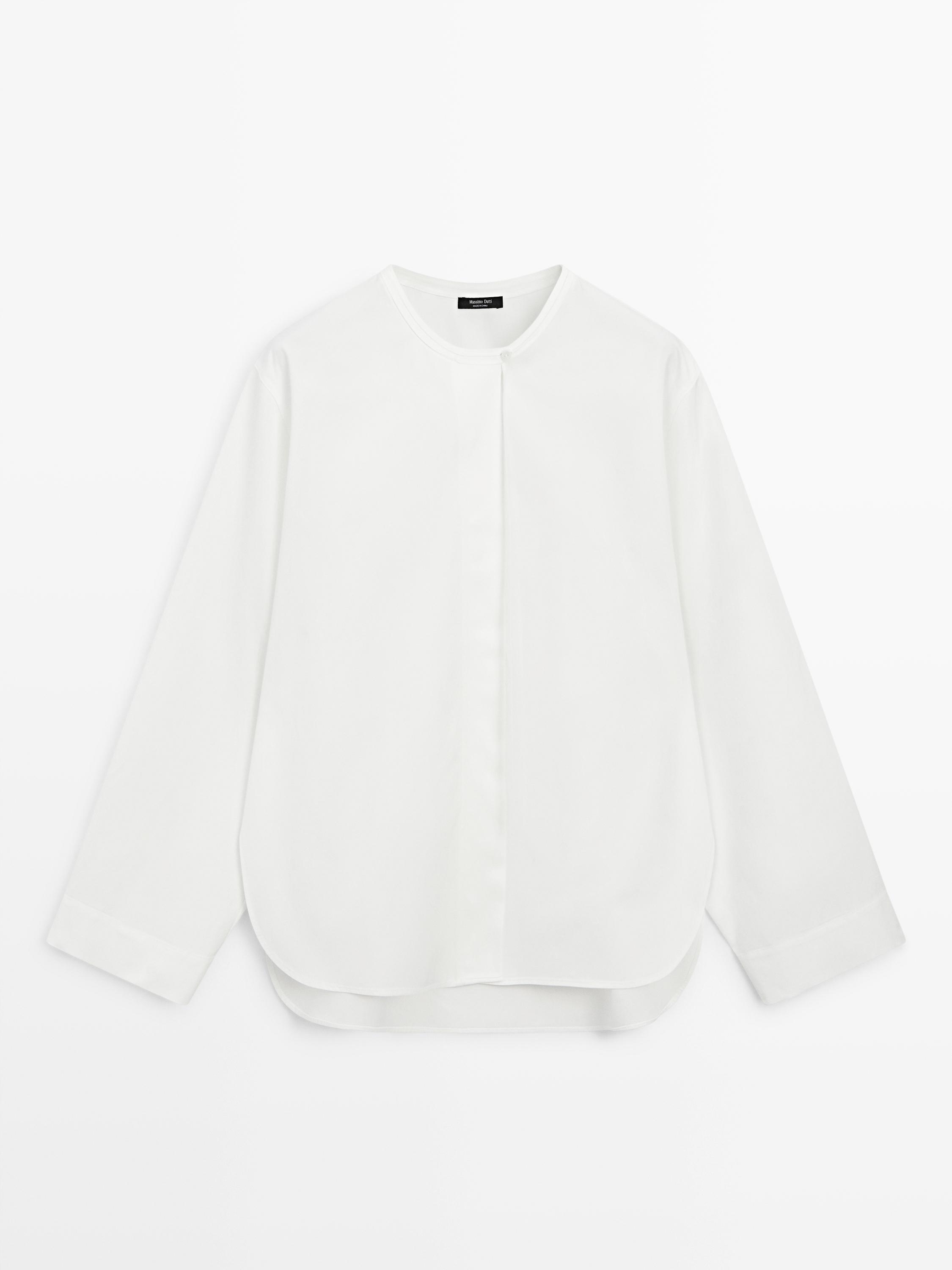 Front view of a flowing white shirt with a round neck, long sleeves, and a rounded hem.