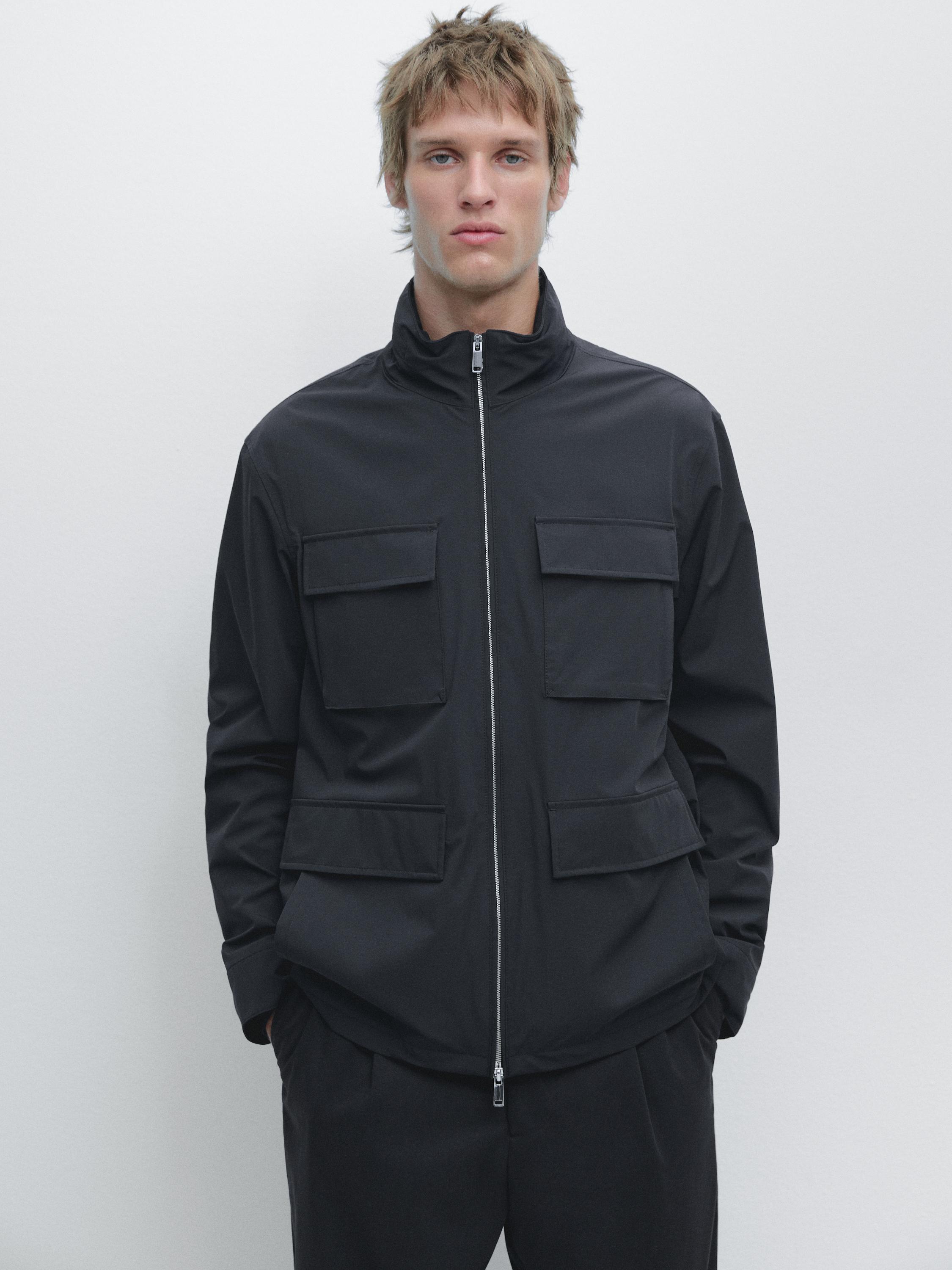 Navy blue jacket set with a front zipper and four flap pockets, paired with dark pants.