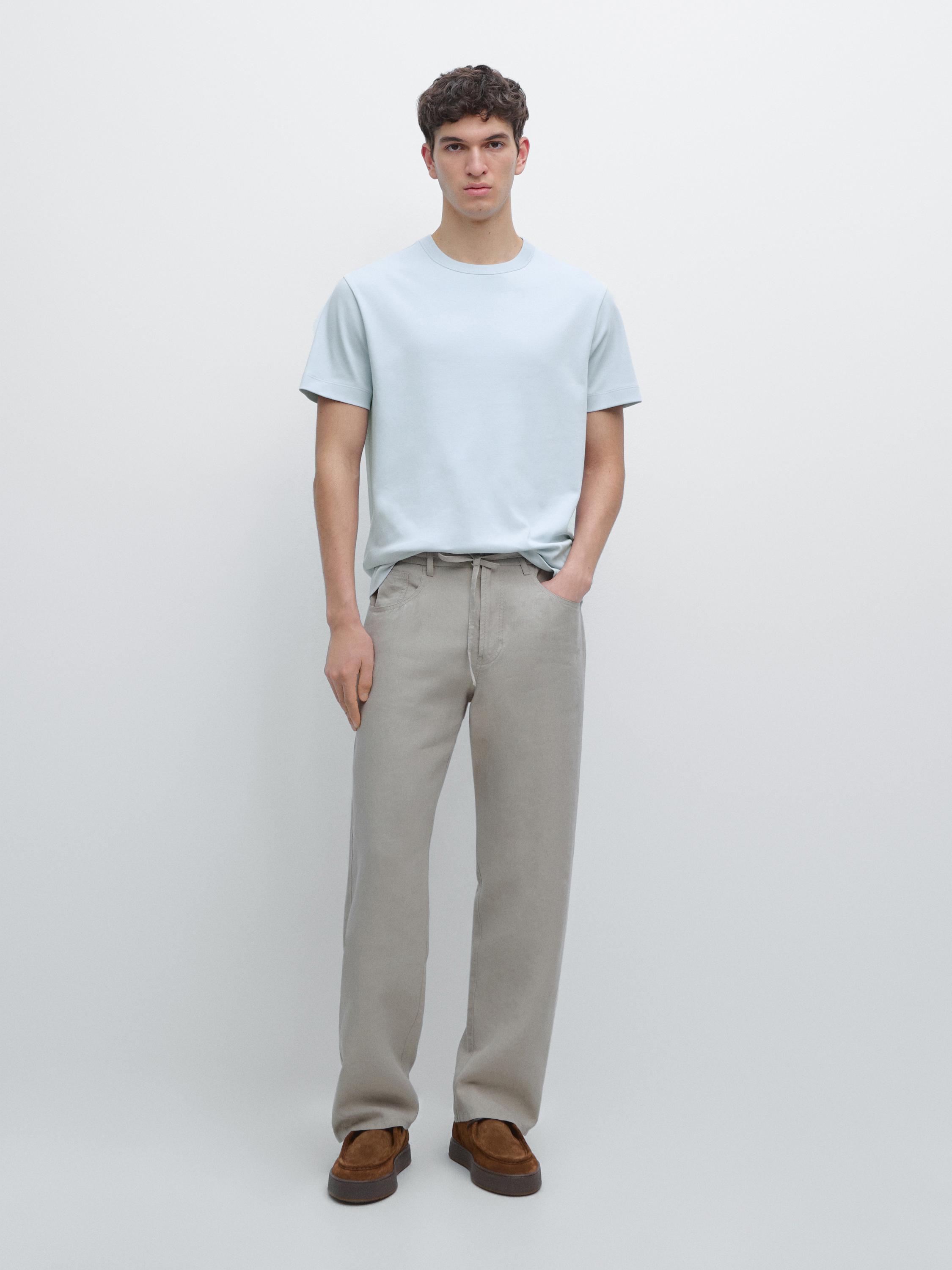 Light blue short-sleeve T-shirt and beige pants set with side pockets.