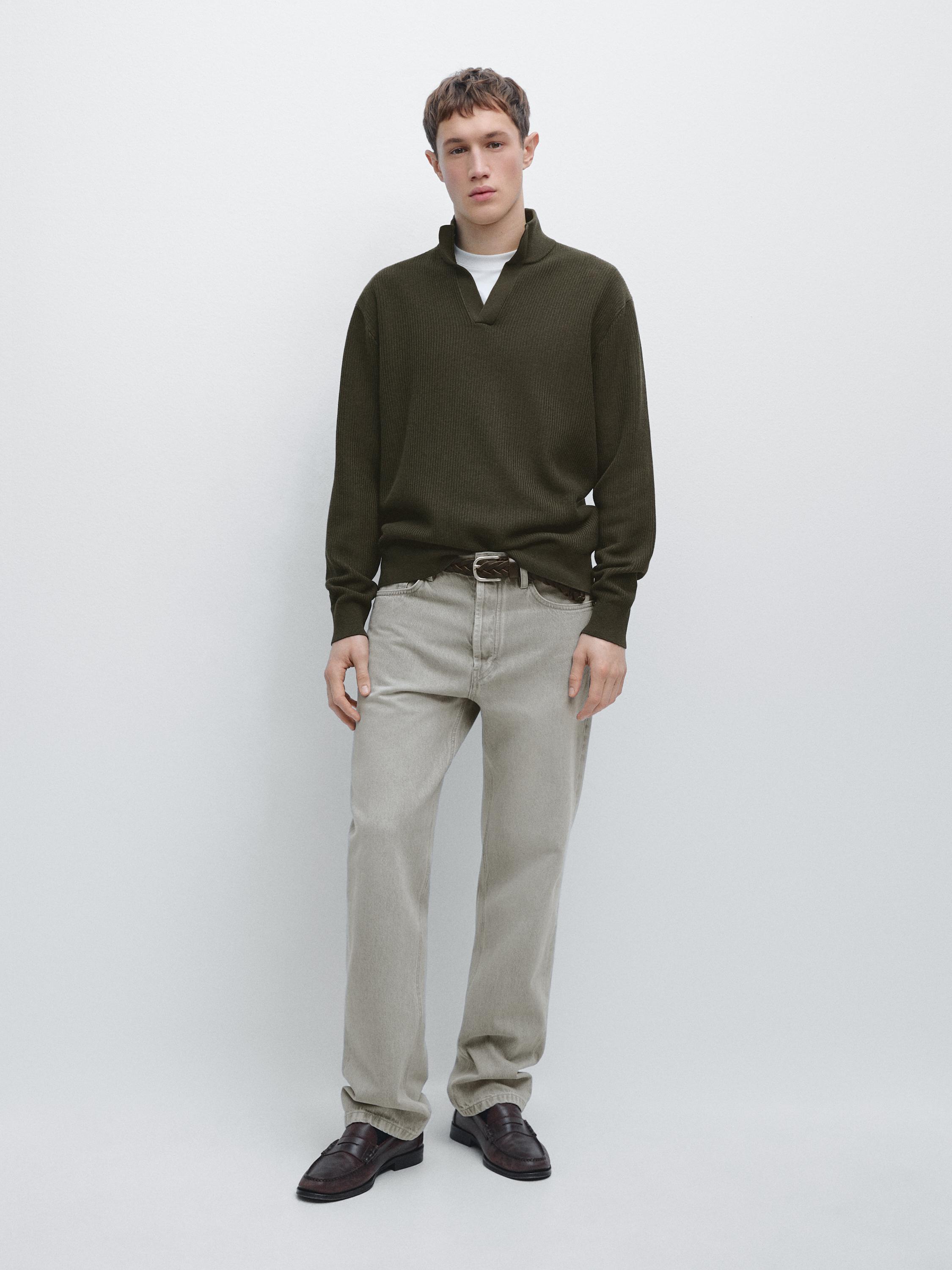 ชุดเสื้อสเวตเตอร์สีเขียวเข้มคอเต่าปลายแหลมและกางเกงขายาวทรงตรงสีเบจ