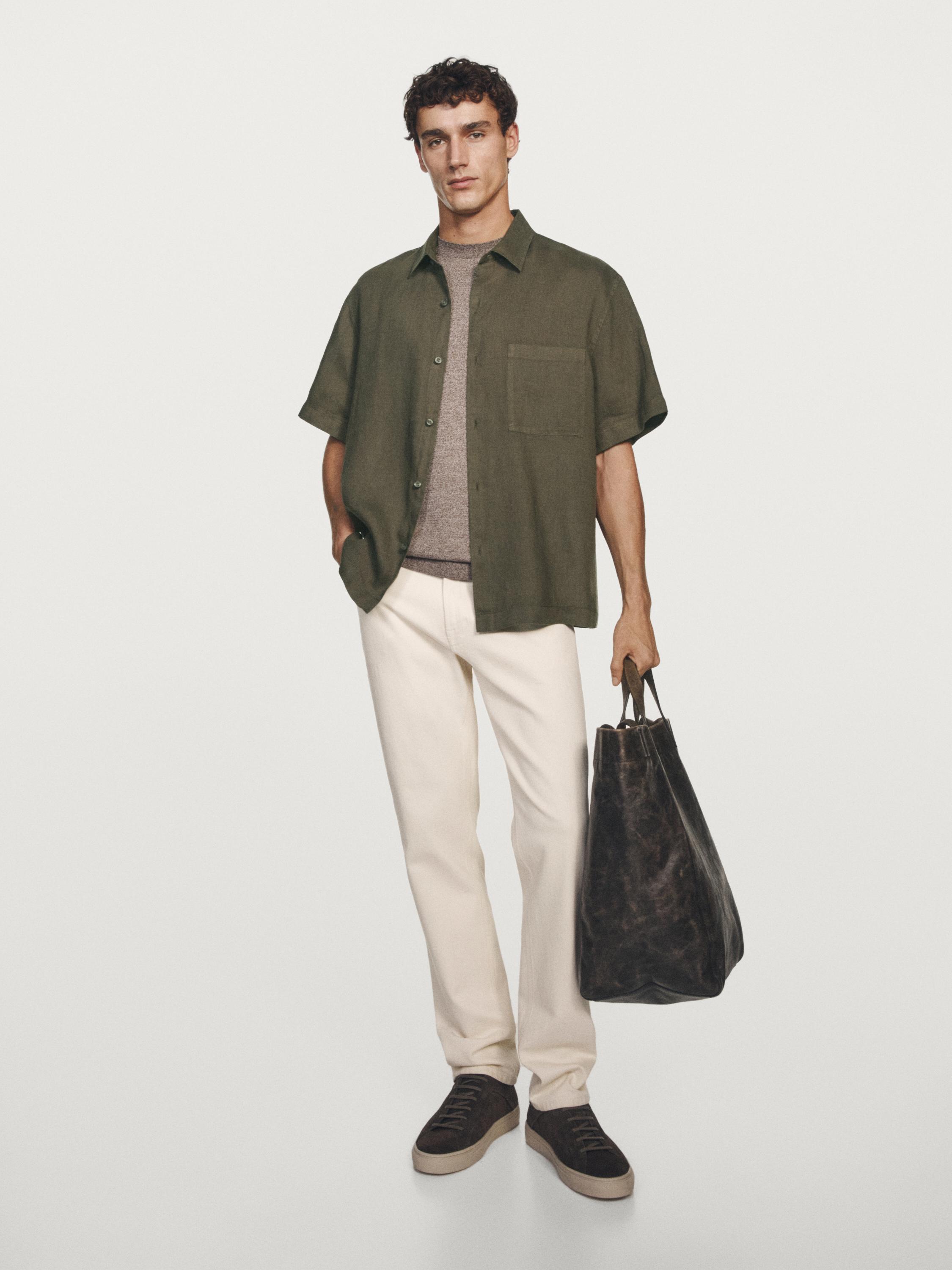 Set koji sadrži zelenu košulju kratkih rukava s prednjim džepom, sivu majicu kratkih rukava, bijele hlače i crne tenisice.