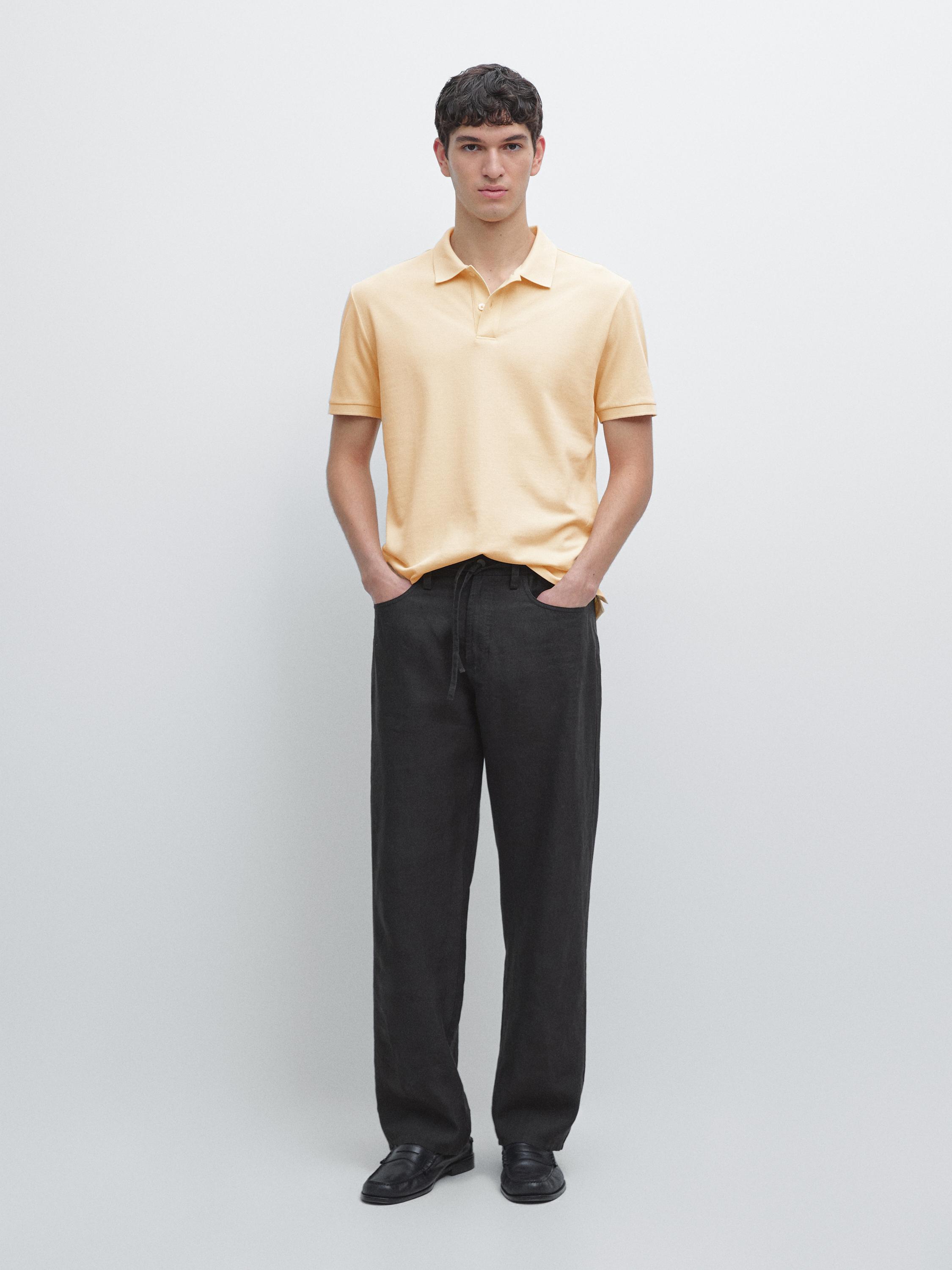 Vanilla short-sleeve polo set and straight black pants with side pockets.