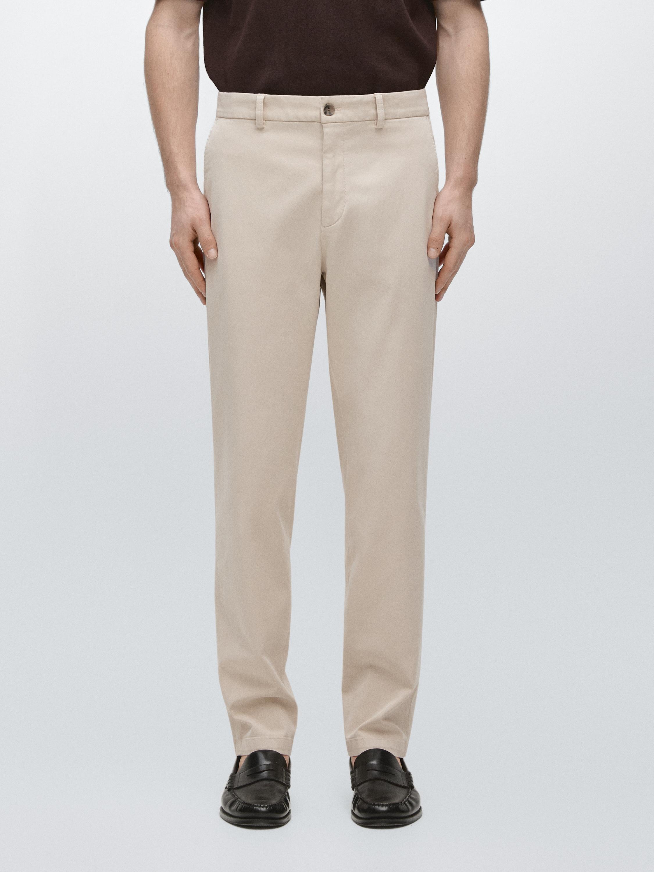 Conjunto de pantalón beige jogger fit con bolsillos laterales y cierre de botón frontal.