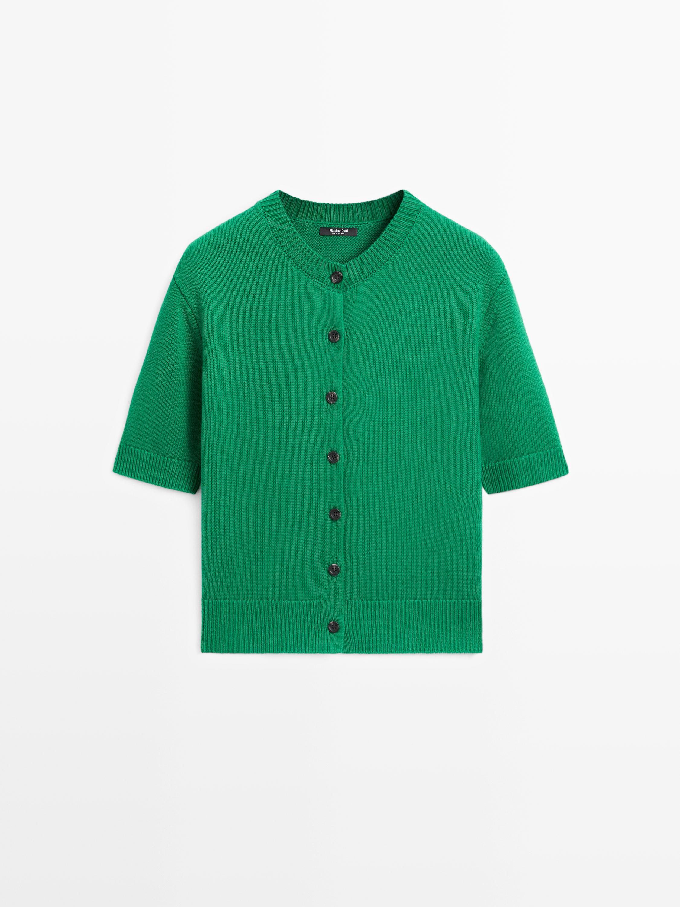 Vista frontal de um cardigan verde de malha com mangas curtas e abotoamento central.