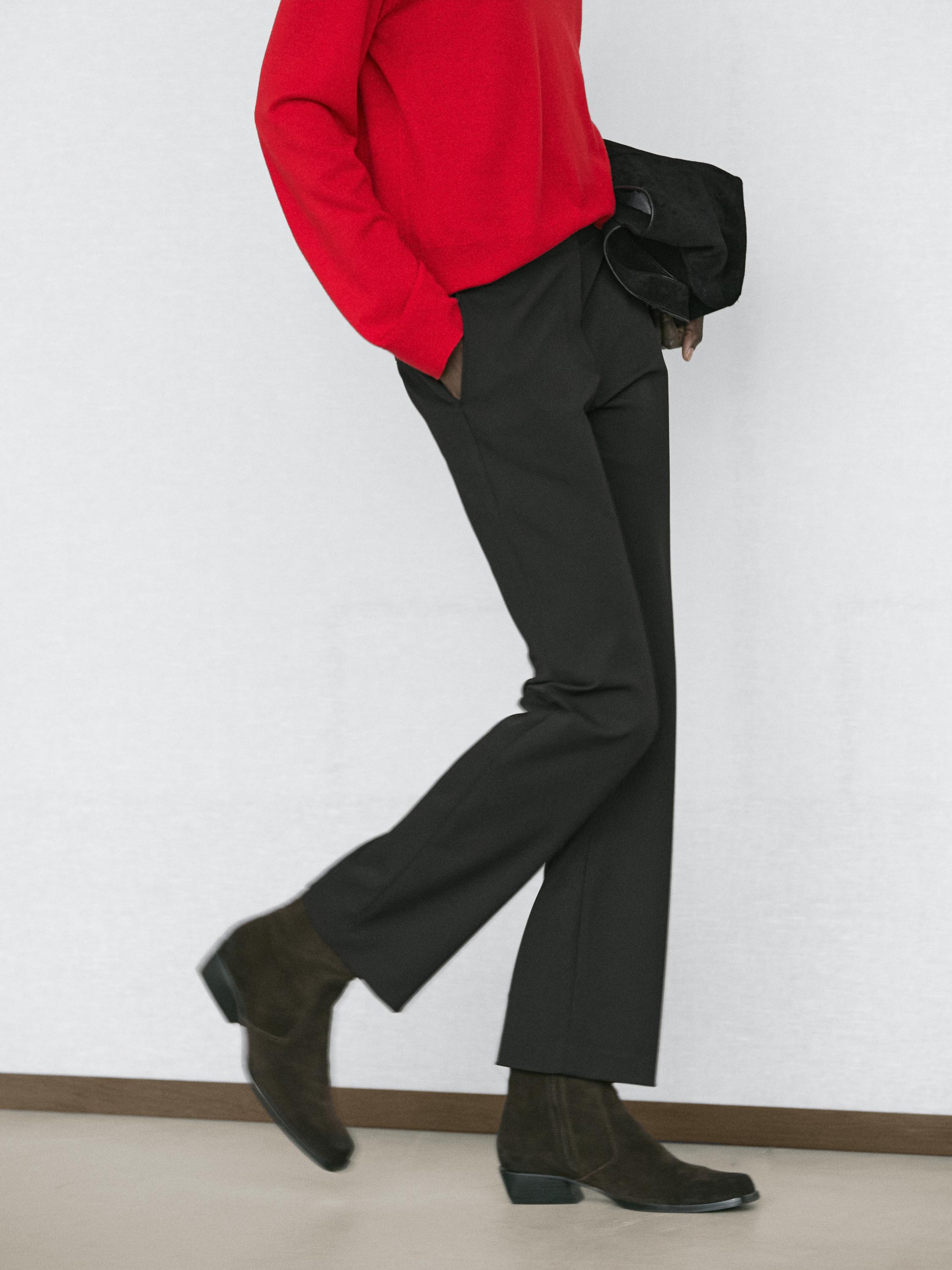 Ensemble pantalon noir straight fit avec poches latérales et pull rouge.