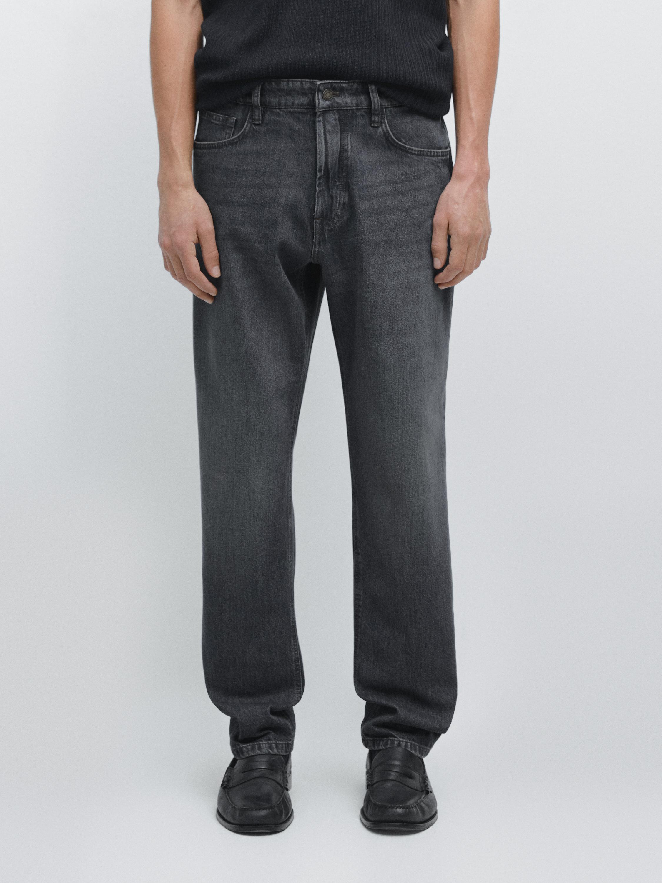 Conjunto de jeans azul-escuro tapered fit com bolsos frontais e traseiros visíveis.