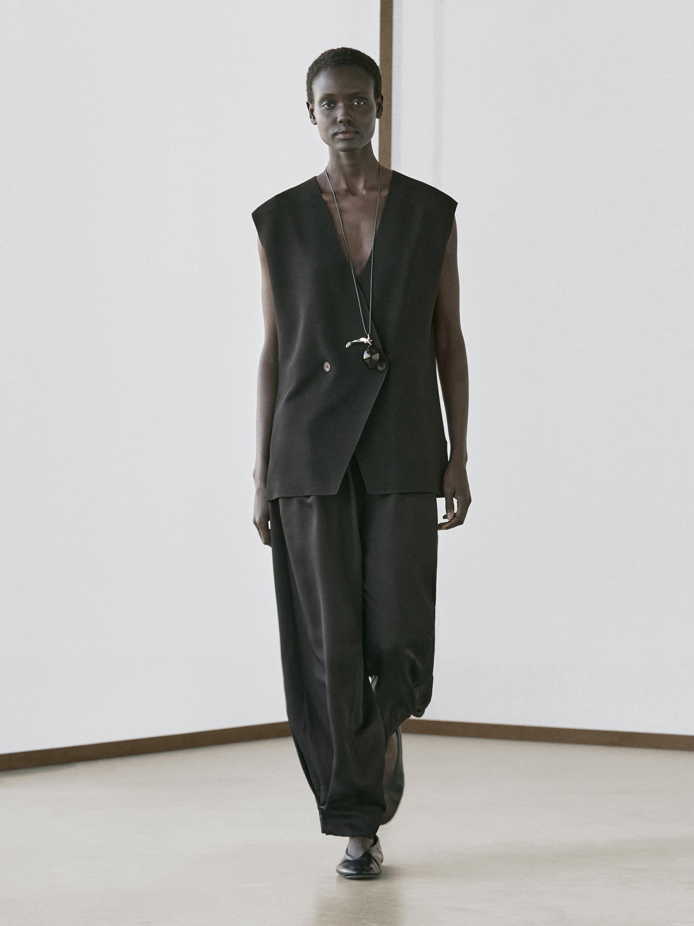Black sleeveless lapel vest and wide black pants set.