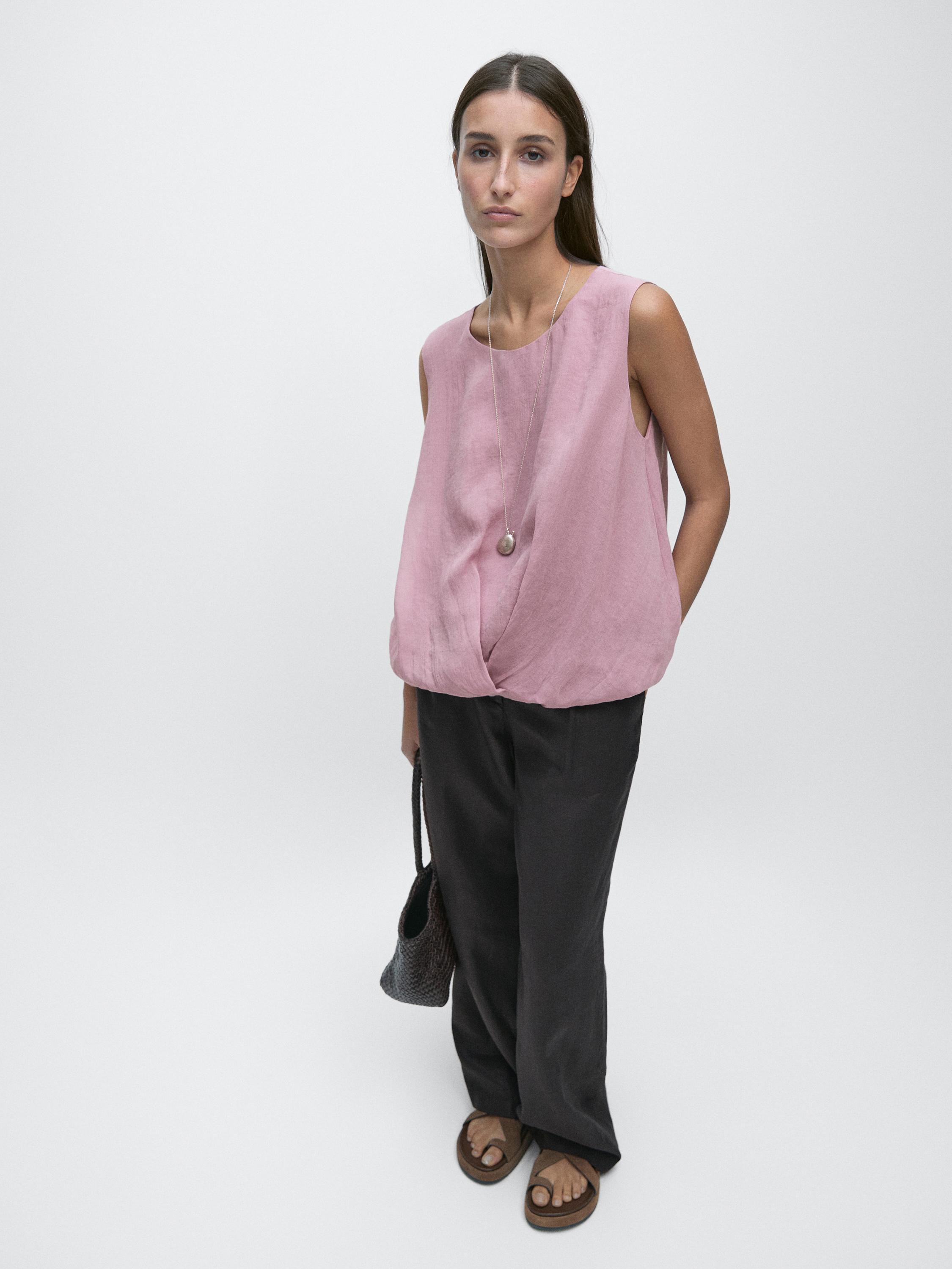 Pink sleeveless top and wide dark pants set.