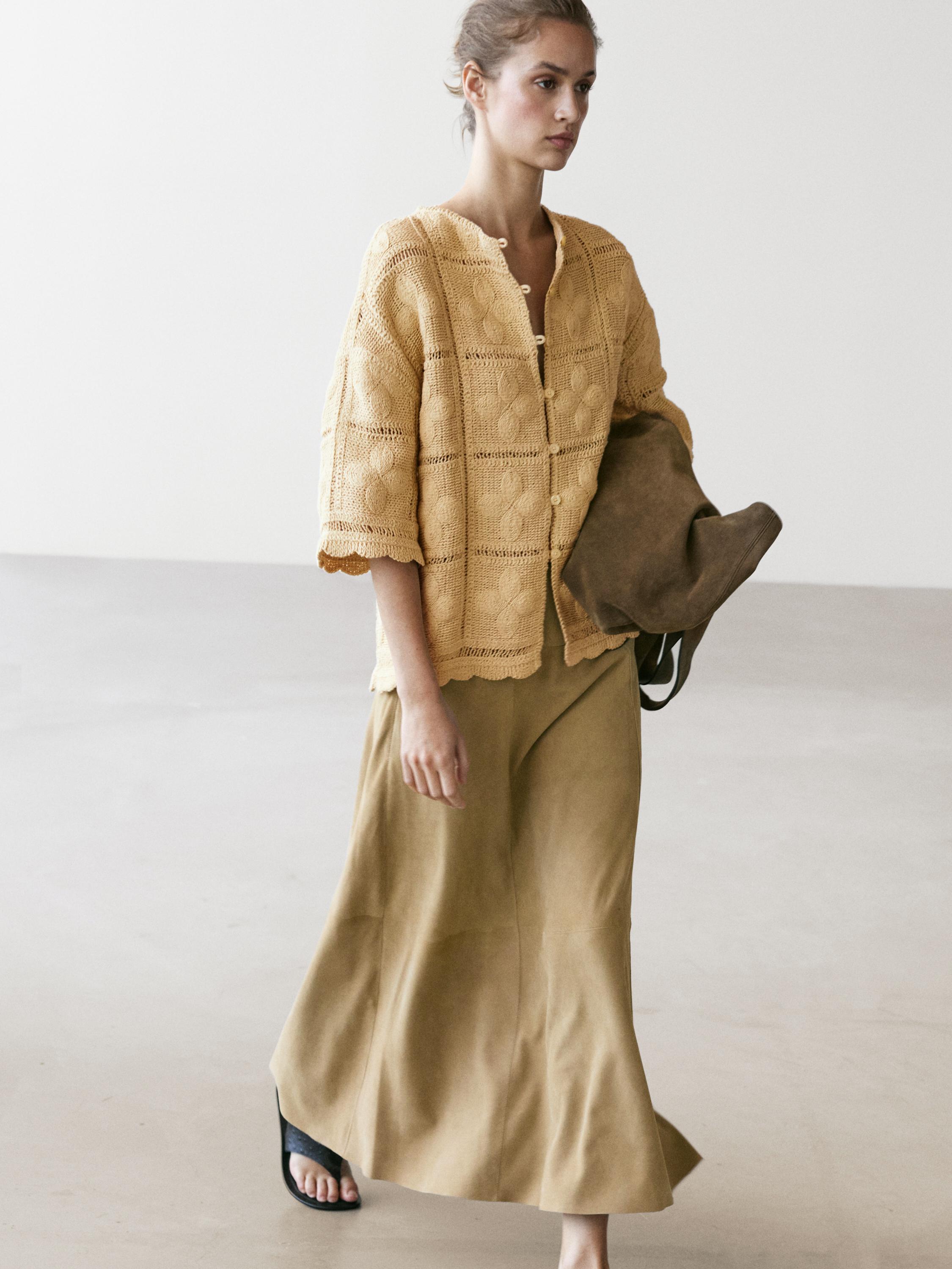 Düğmeli vanilya rengi tığ işi ceket ve bej uzun etek takımı.