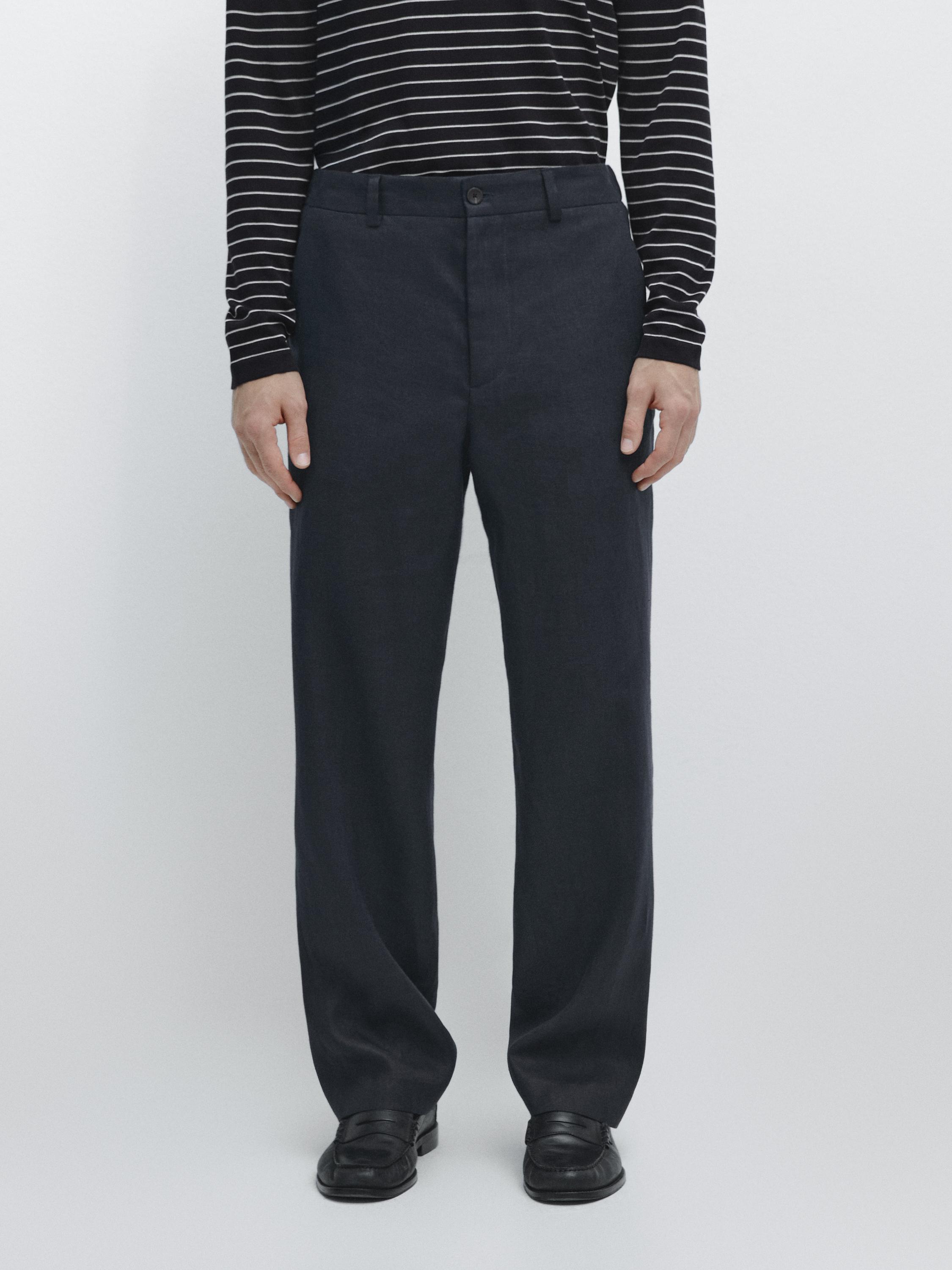 Conjunto de pantalón azul marino con bolsillos laterales y botón frontal, combinado con camiseta de rayas negras y blancas.