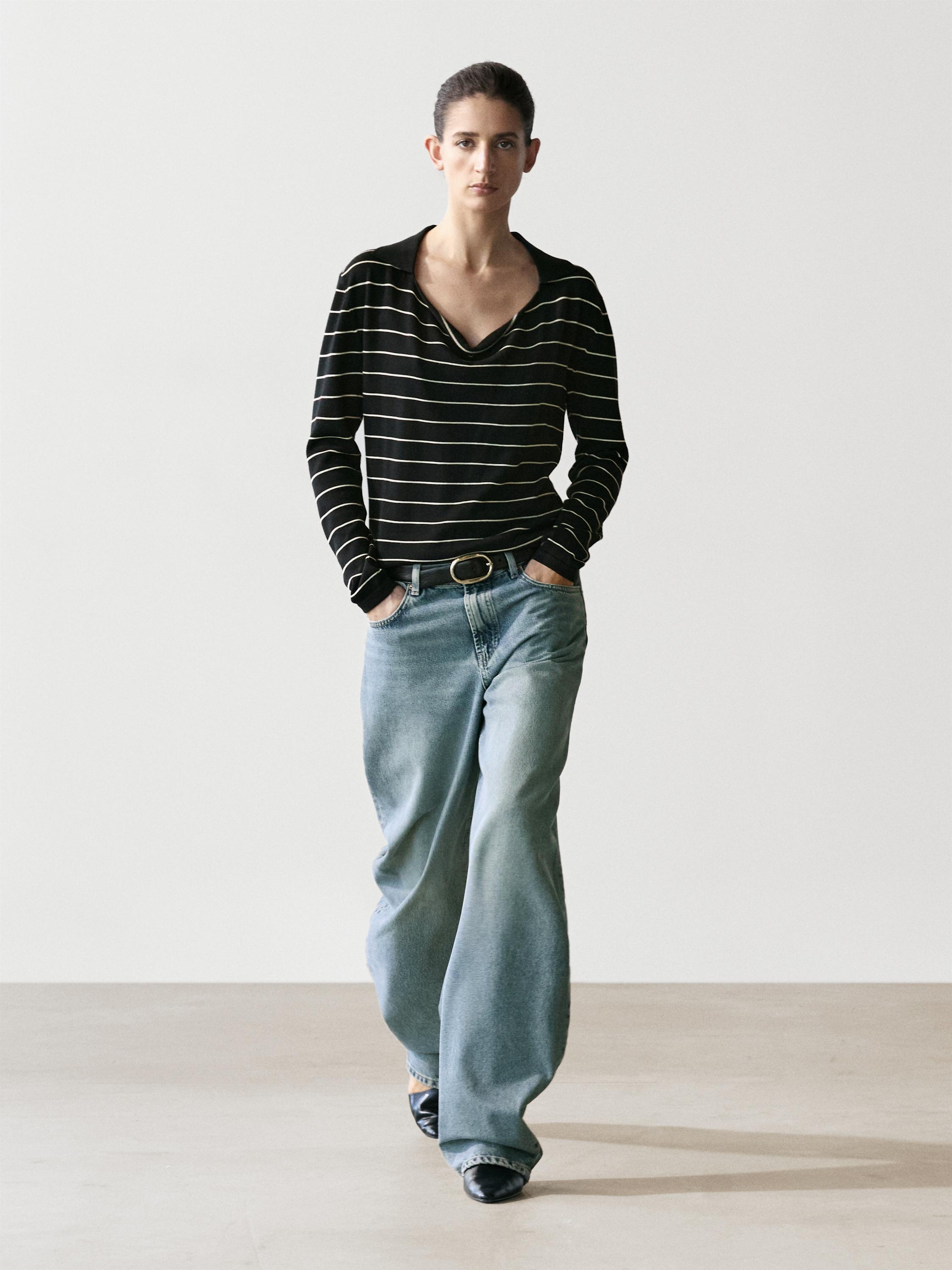 Marineblauwe jersey set met witte strepen en wijde blauwe jeans met zijzakken.