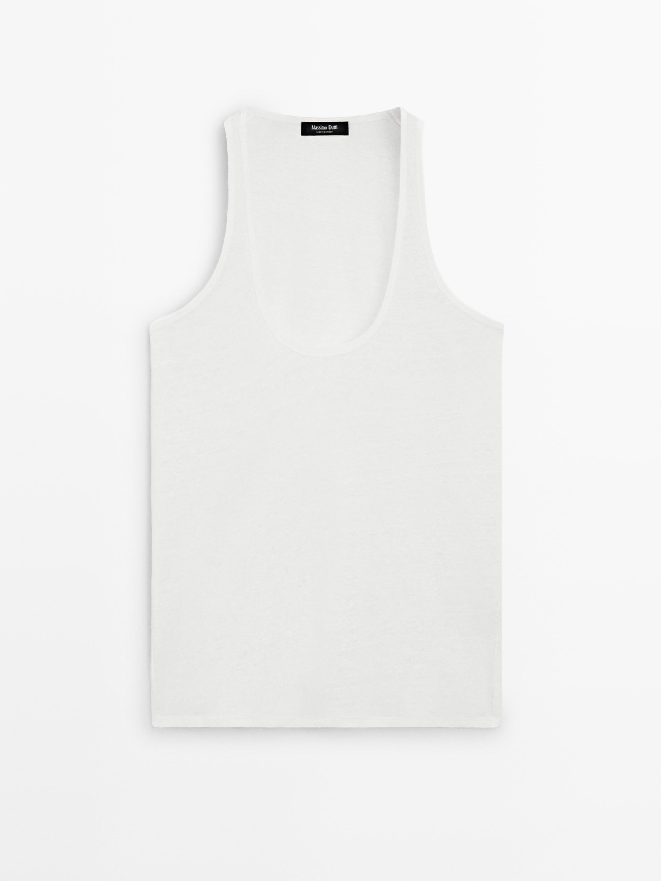 "Vue de face d'un débardeur blanc cassé à col rond avec une étiquette noire à l'intérieur du col."