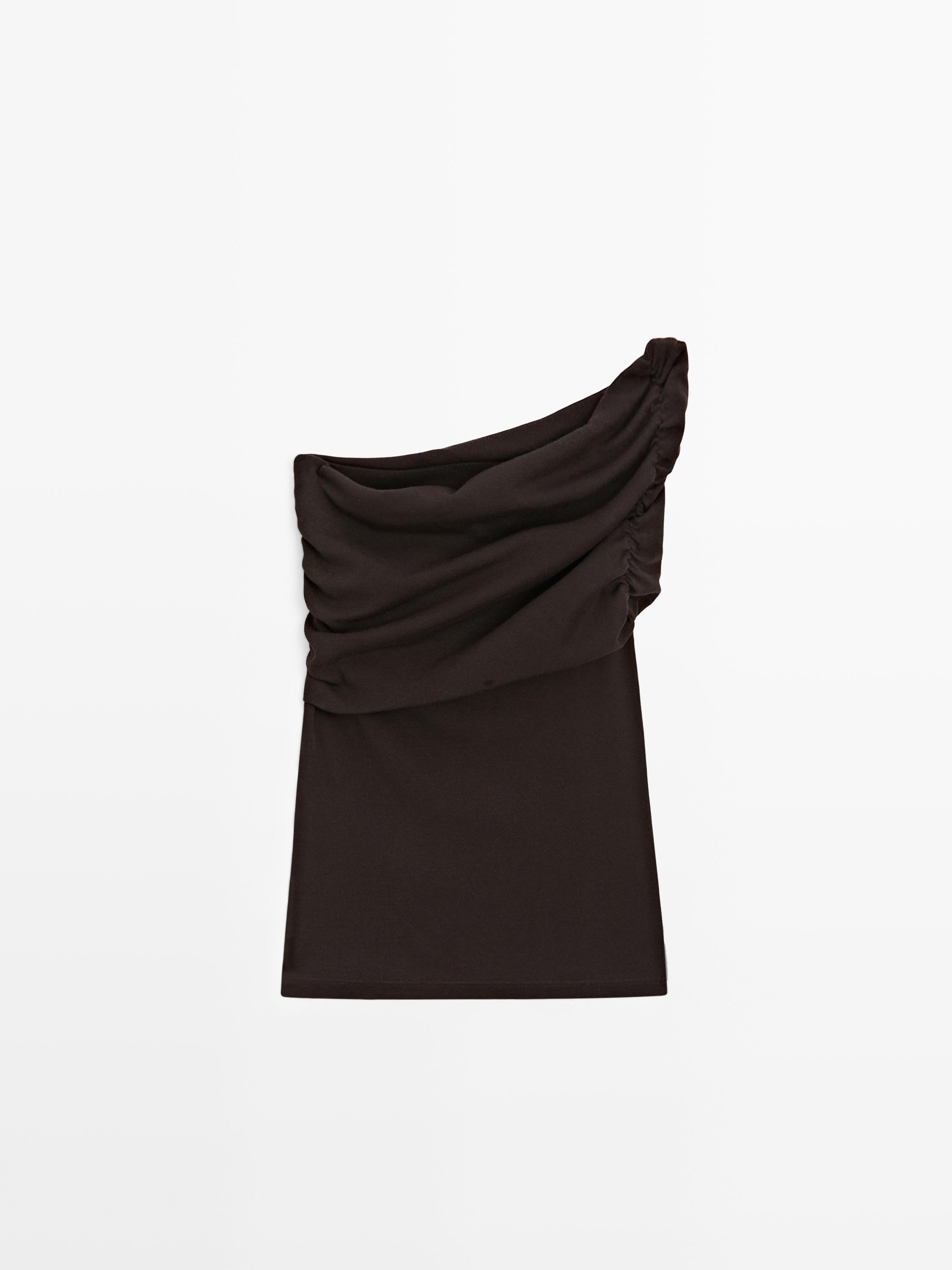 Vista frontal de camiseta sin mangas café con diseño asimétrico y fruncido en el hombro.