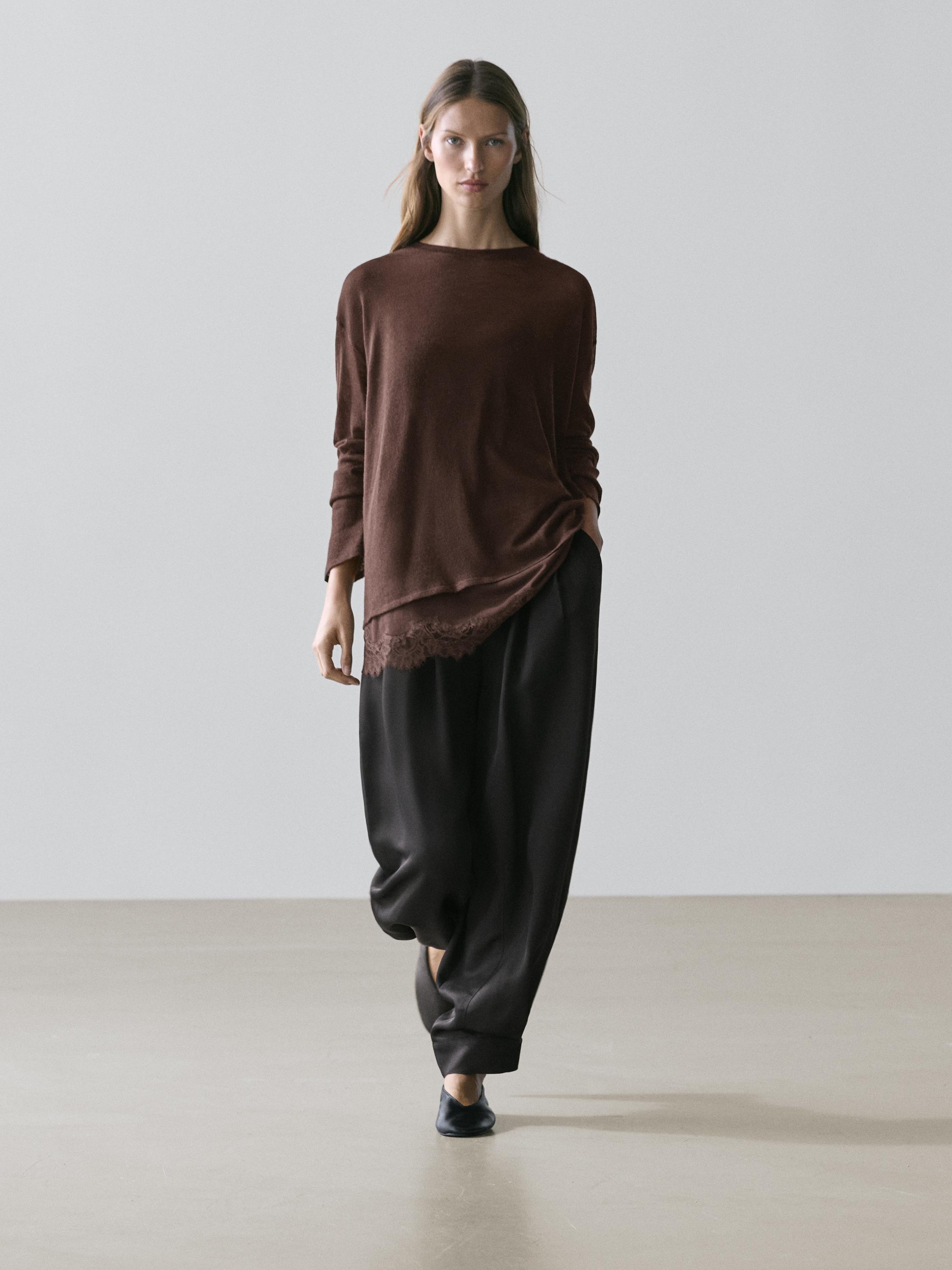 Set aus langärmeligem braunem T-Shirt mit Spitzendetail am Saum und weiter schwarzer Hose.