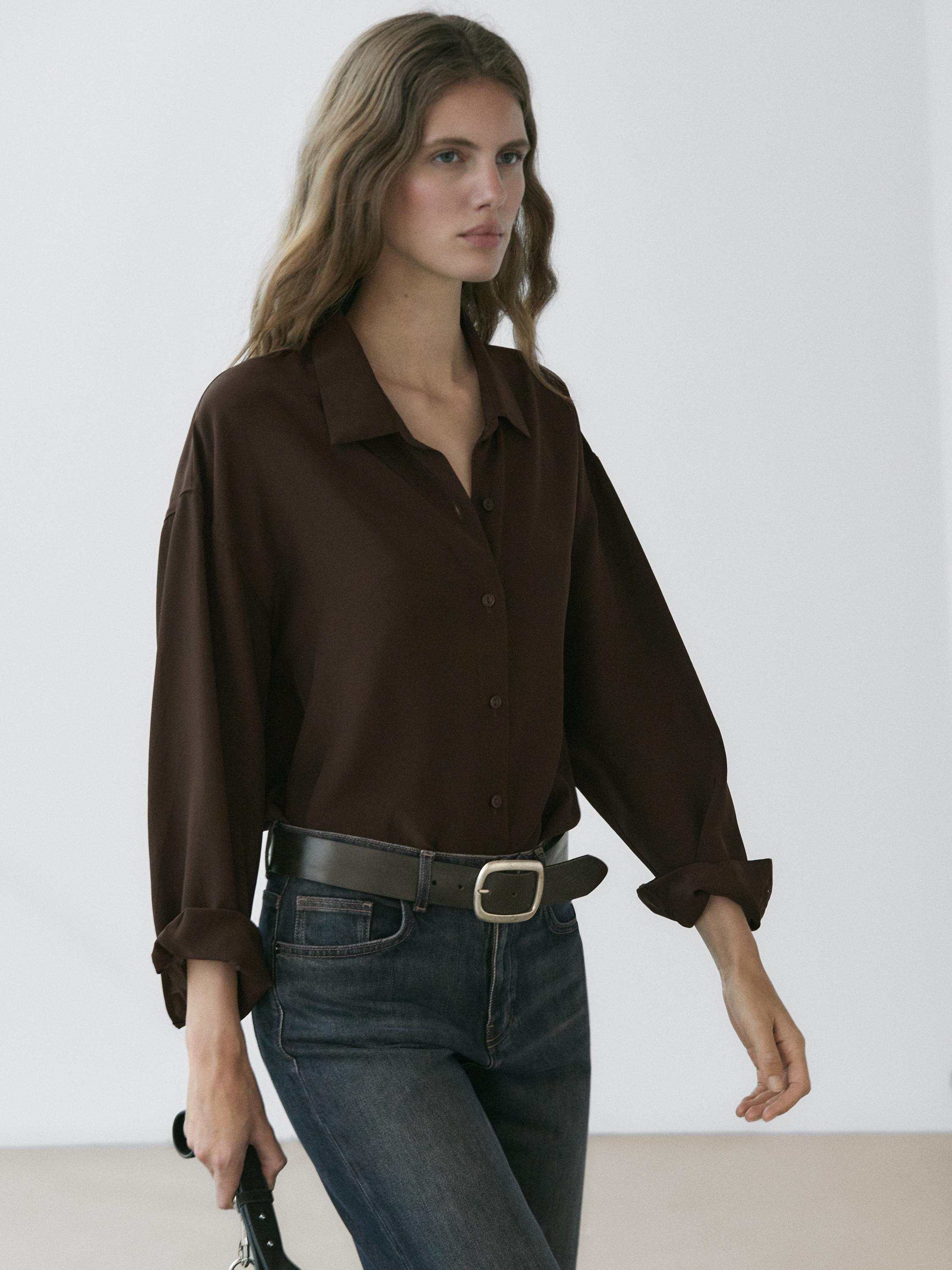 Ensemble de chemise fluide marron boutonnée et jean bleu foncé avec ceinture noire.