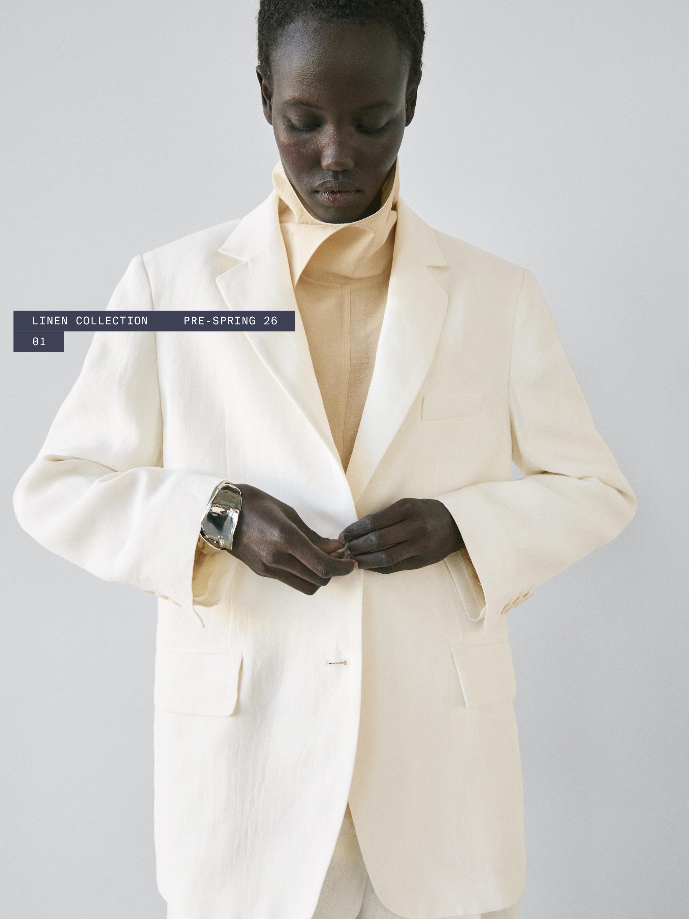 Plano mediu de blazer alb rupt cu buzunare frontale cu clapă și text "LINEN COLLECTION PRE-SPRING 26 01".