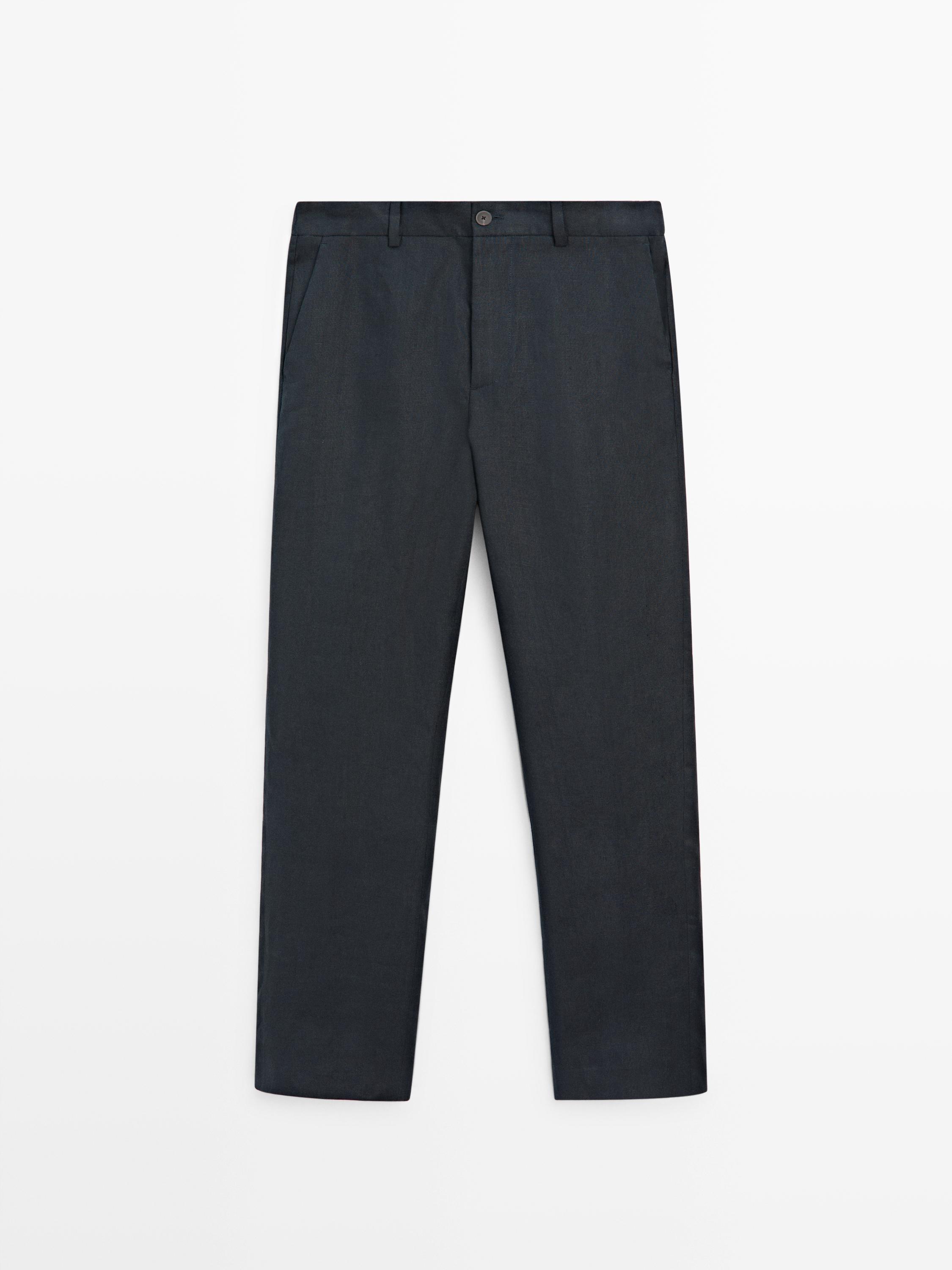 Itsas urdineko praken aurrealdeko ikuspegia, alboetako poltsikoekin eta botoi-ixtearekin.