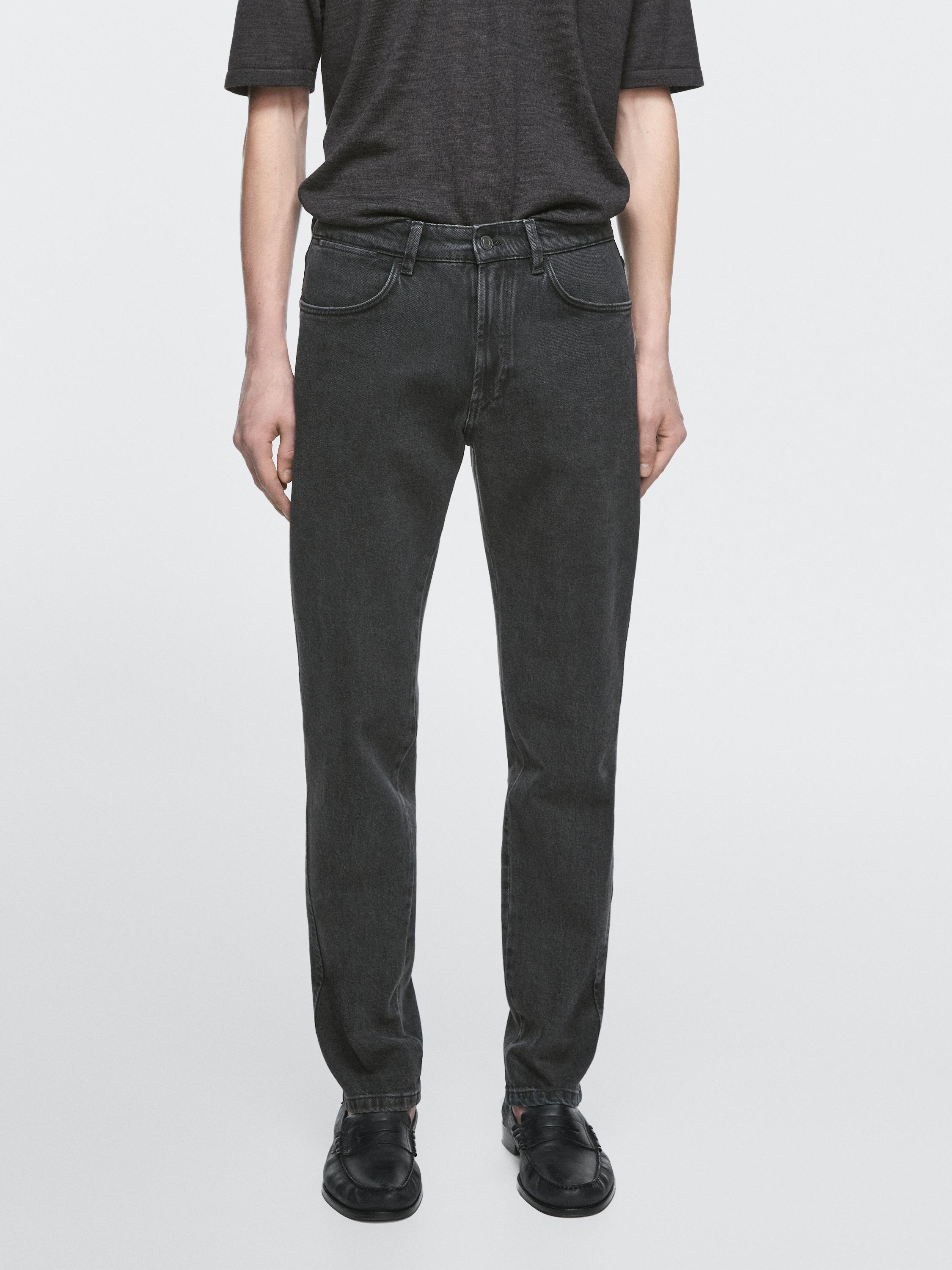 طقم تي شيرت رمادي داكن وجينز أسود بجيوب أمامية وخلفية ظاهرة.