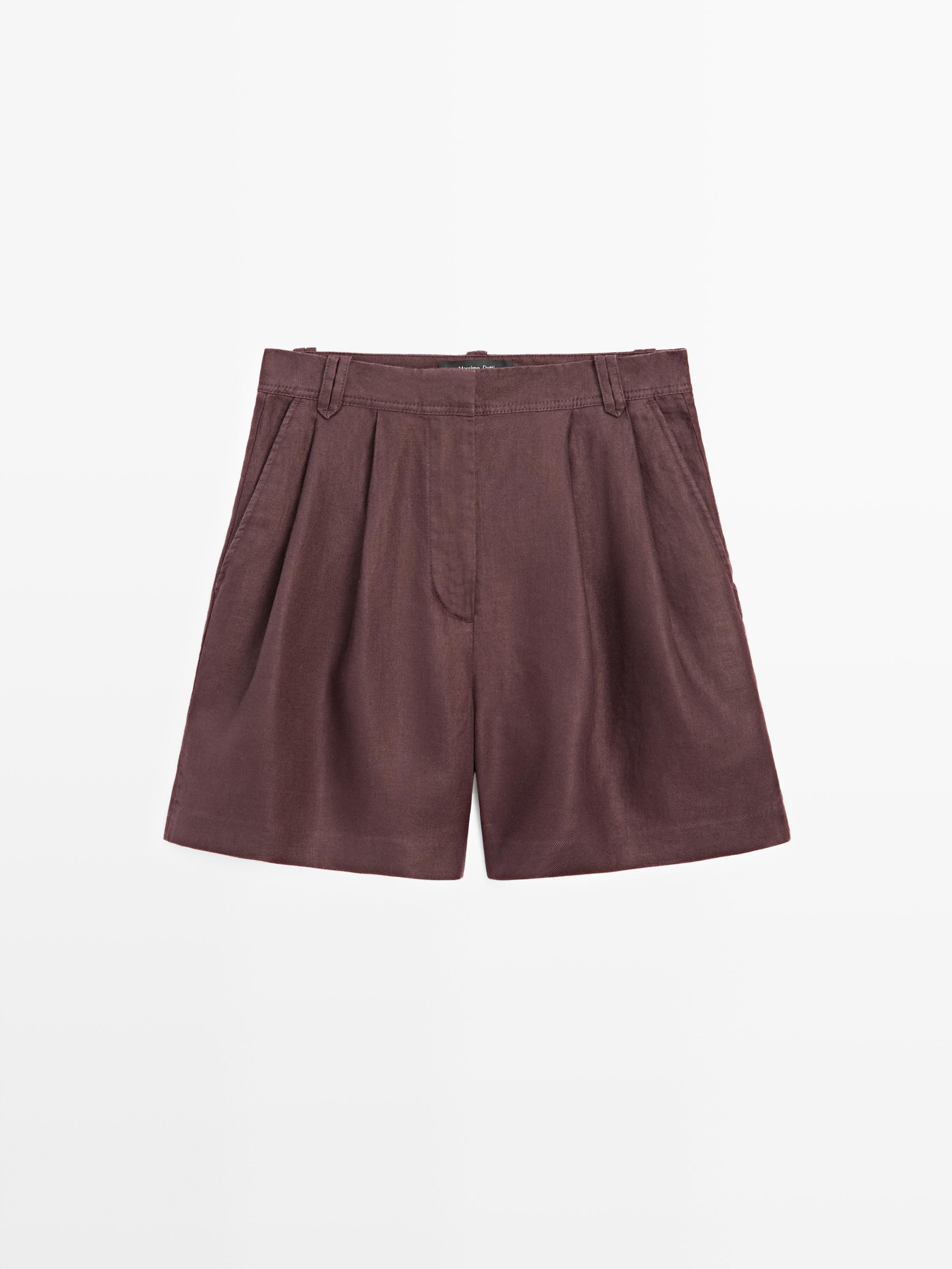 Front view of eggplant-colored Bermuda shorts with pleats and side pockets.