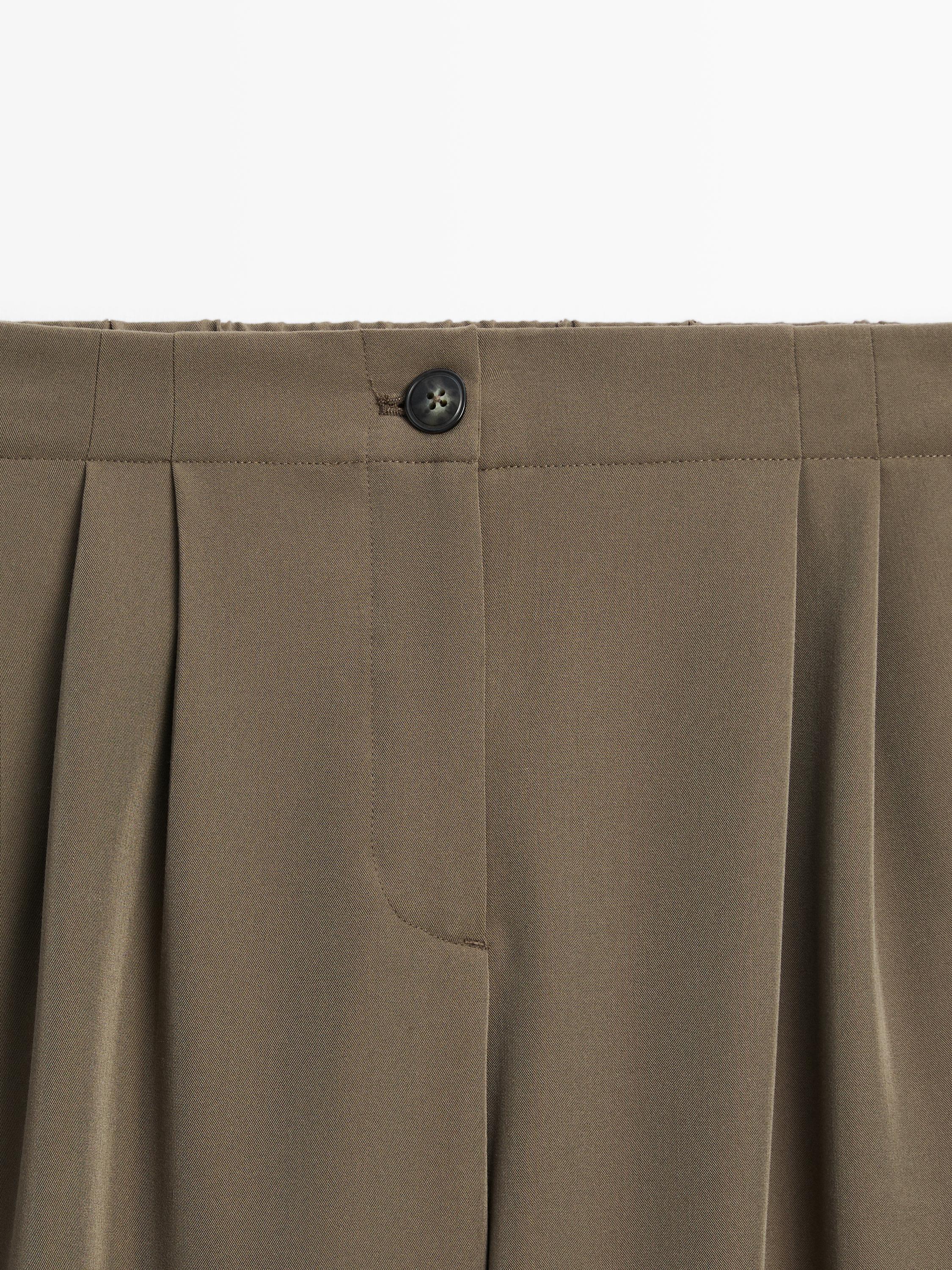 Brīvi krītošas bikses ar platām starām un ielocēm