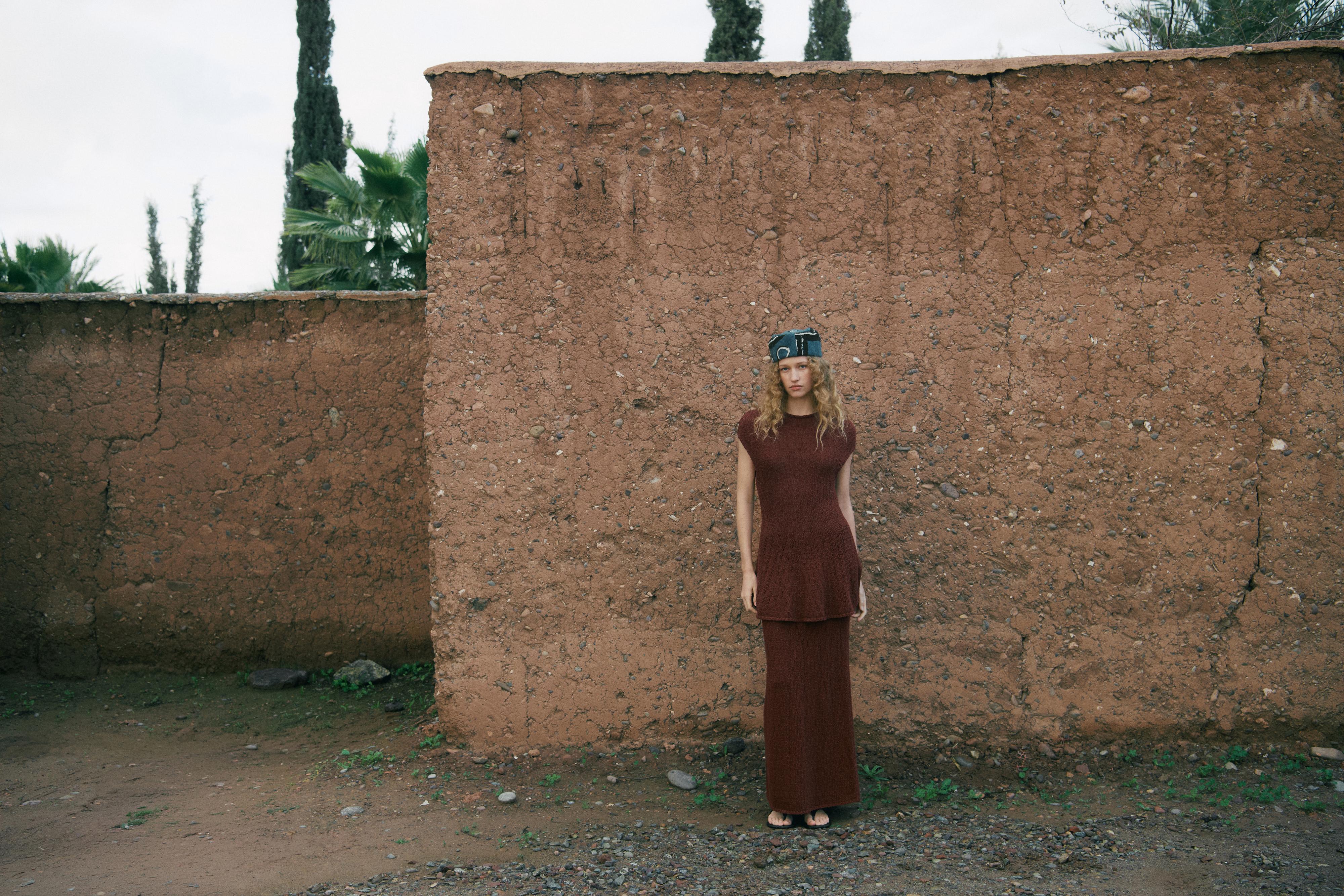 Ensemble robe longue marron sans manches et bandeau noir avec détails métalliques.