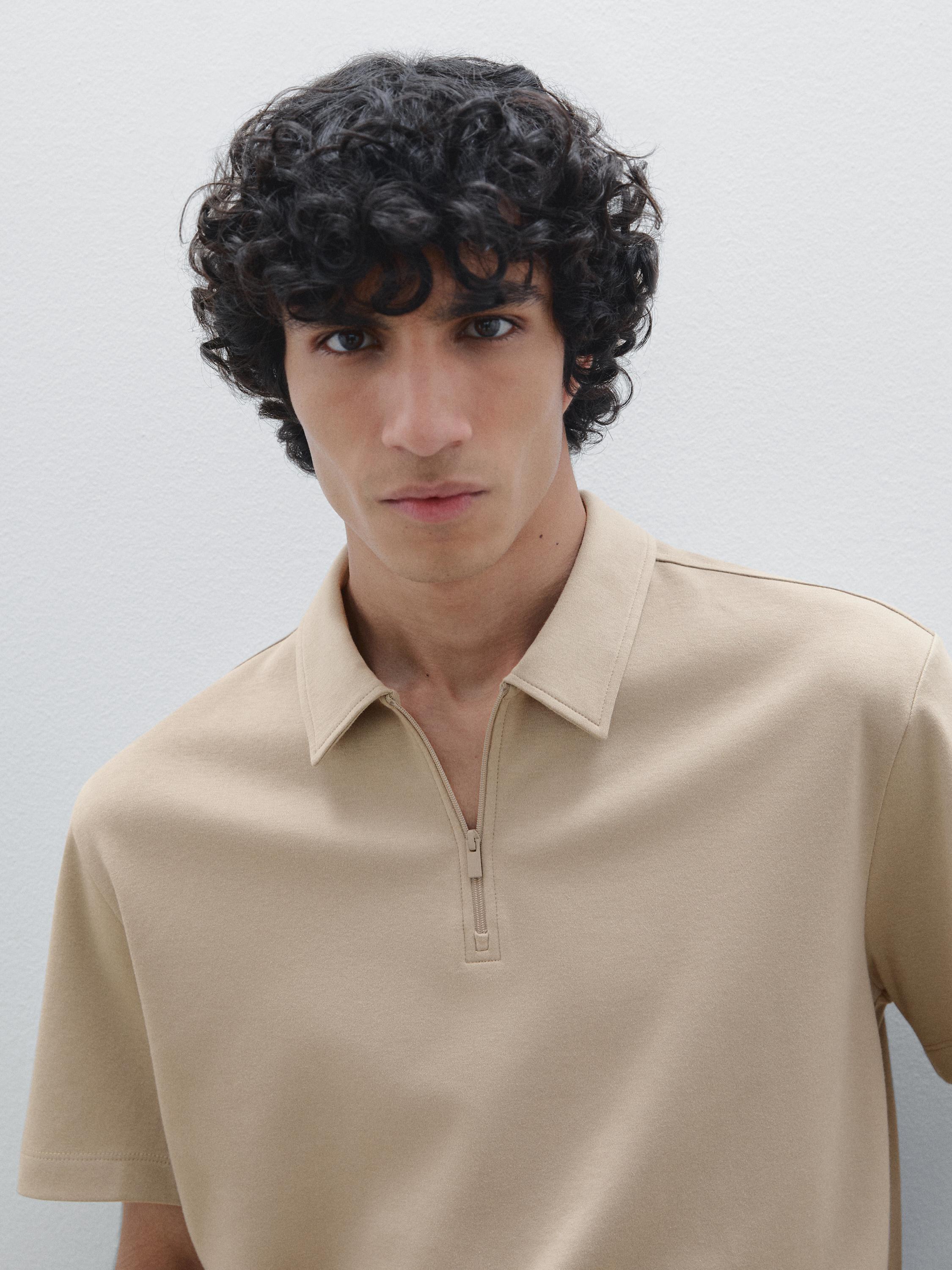 Gros plan sur un polo beige avec fermeture éclair frontale et col classique.