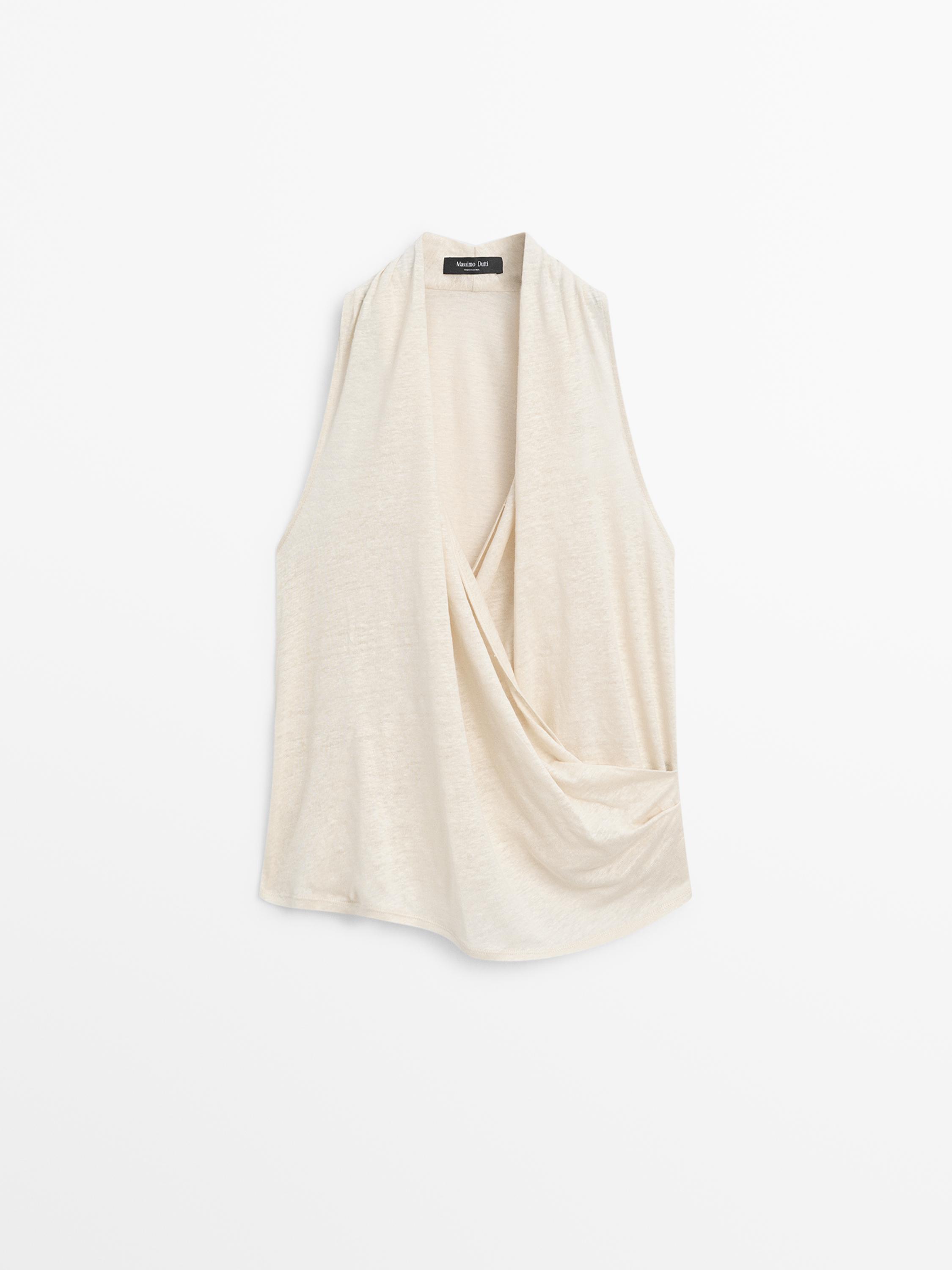 Vista frontal de playera sin mangas beige con escote drapeado.