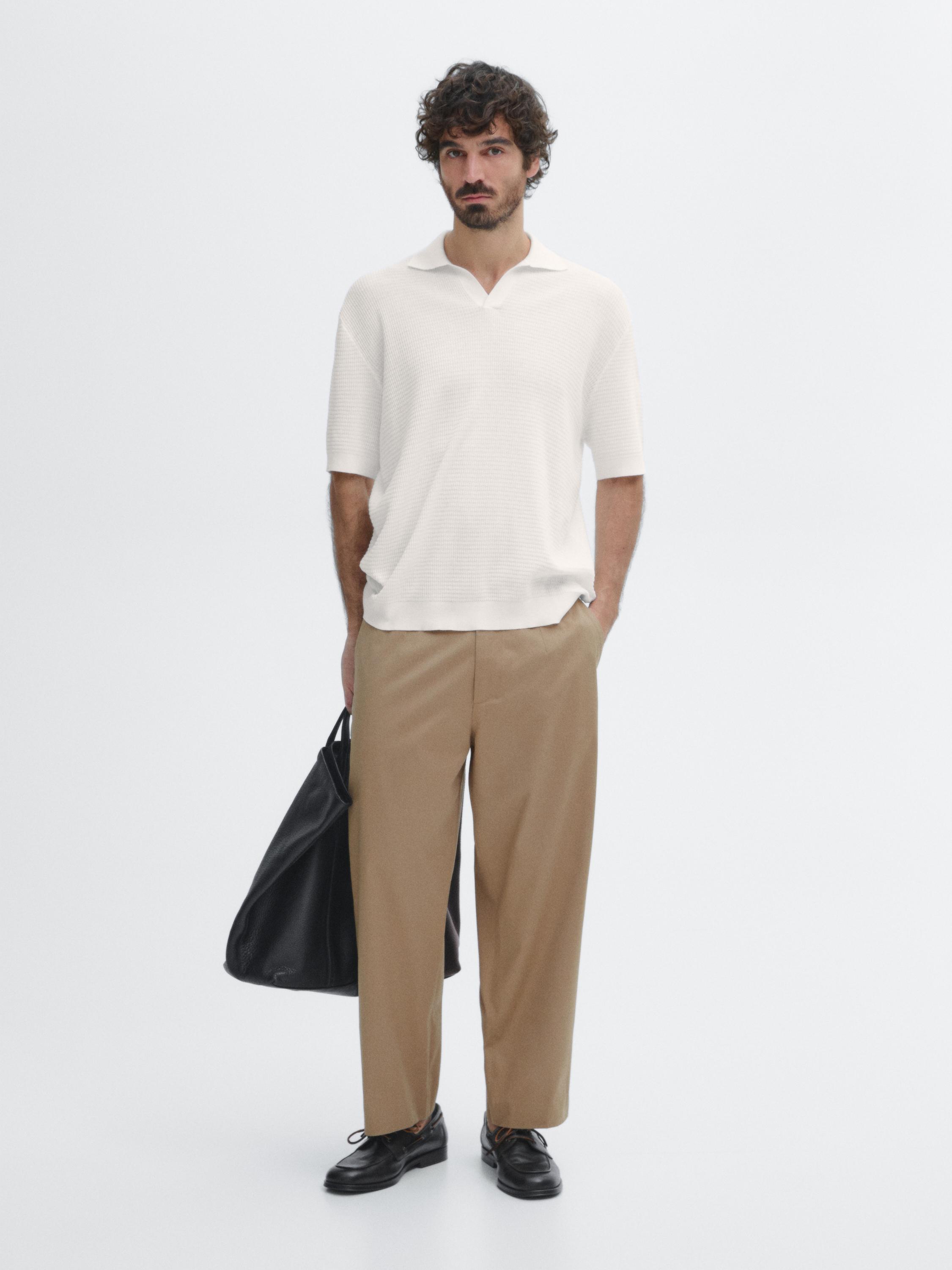 Ensemble polo blanc et pantalon beige avec sac noir