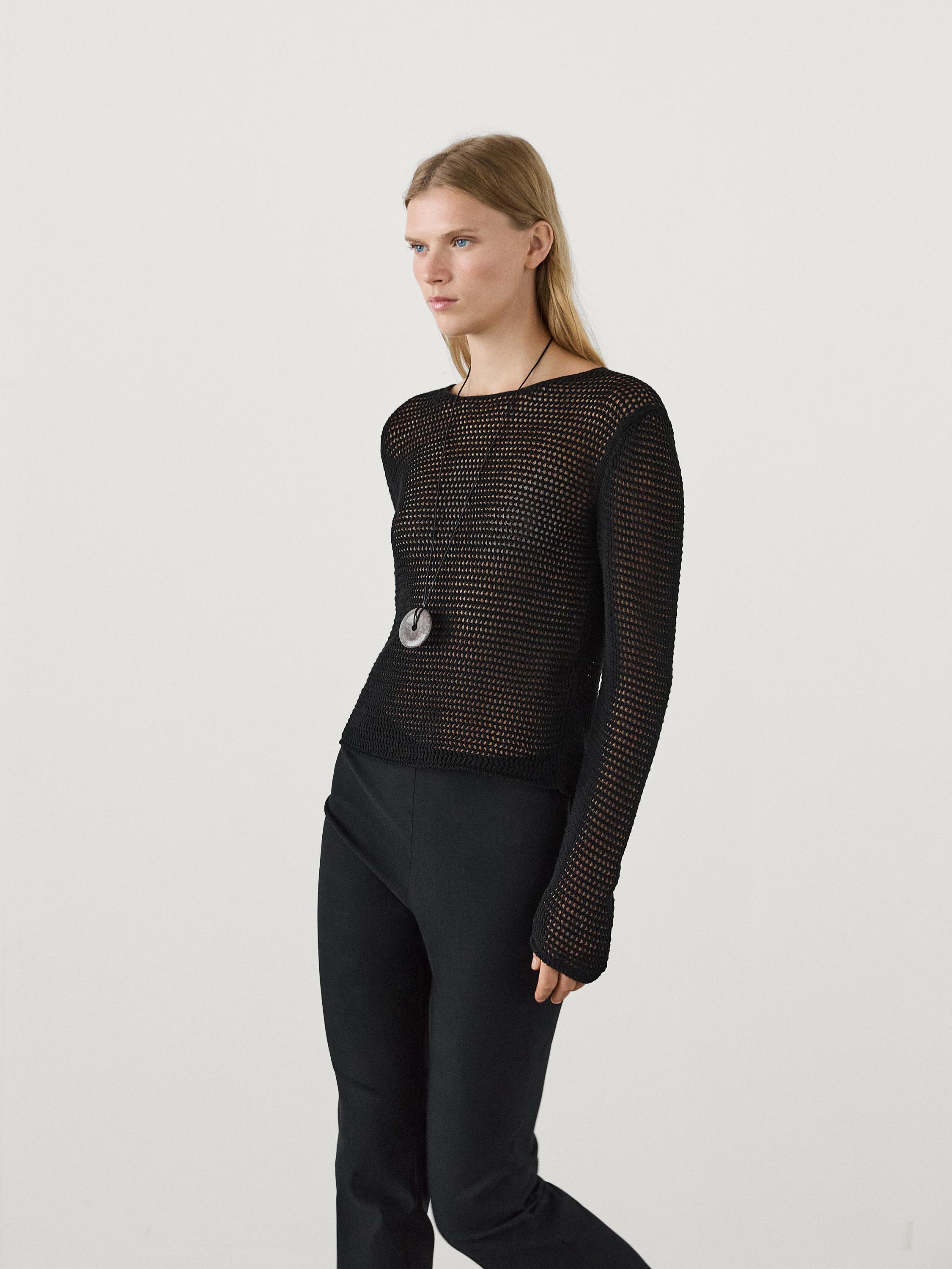 Ensemble composé d'un haut noir en maille et d'un pantalon noir.